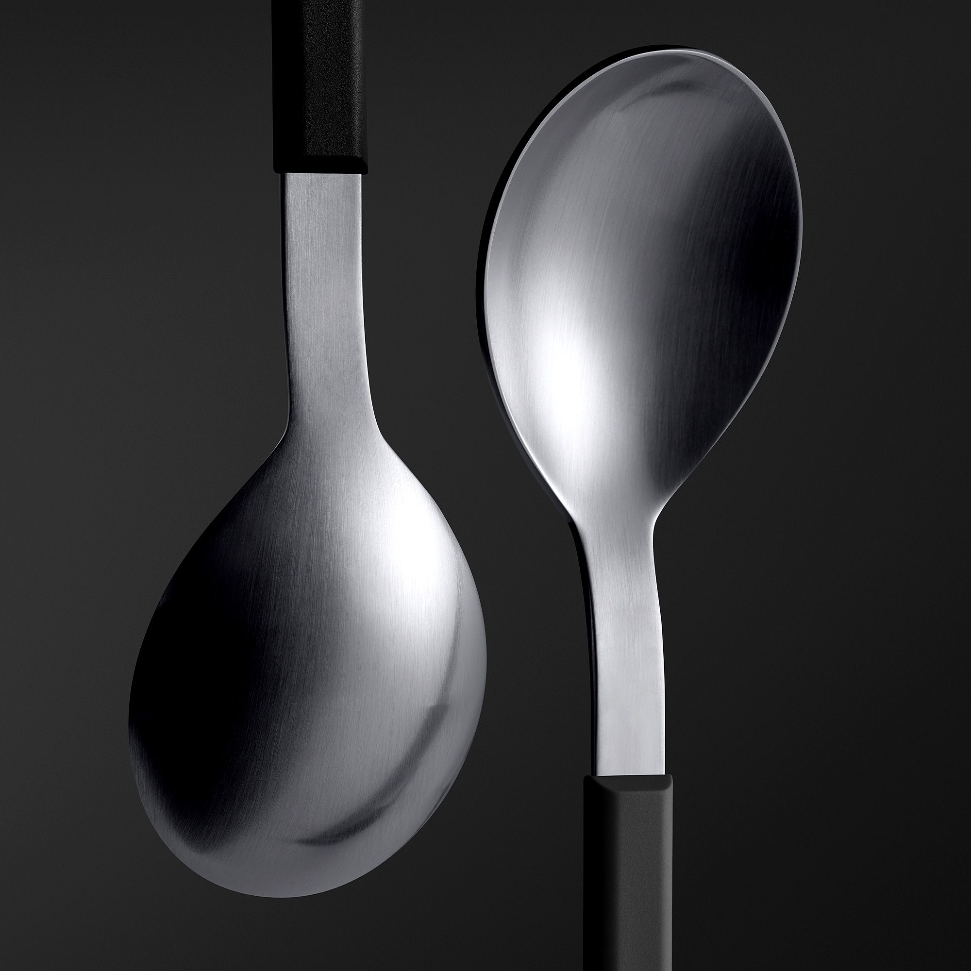 Zwei moderne Edelstahl-Löffel mit schwarzem Griff