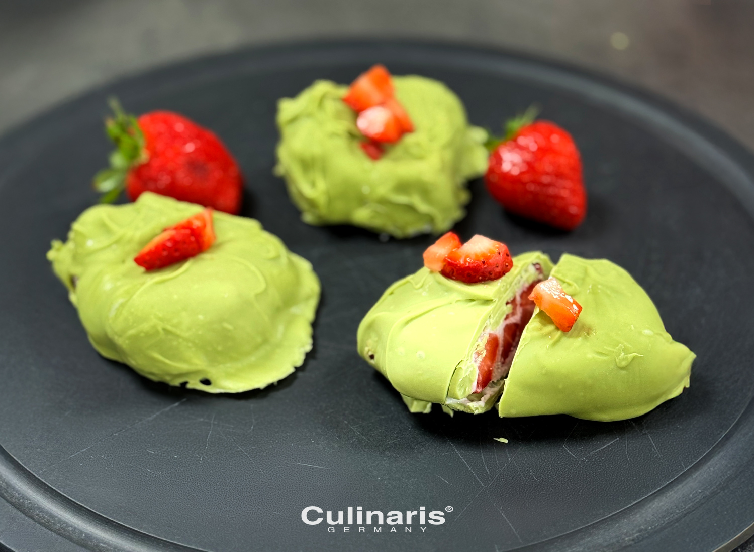 Filled strawberry dessert with green glaze on plate