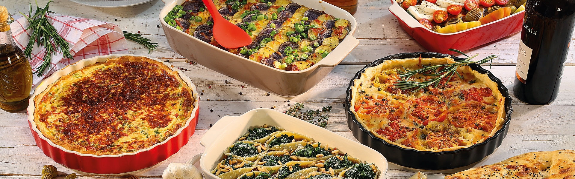 Assorted bakes and quiches in colourful ceramic dishes