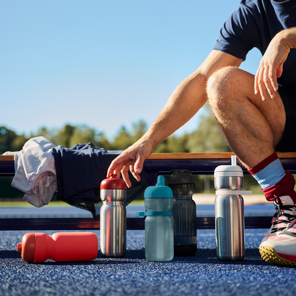 Athlete reaching for stainless steel bottle at pitch side