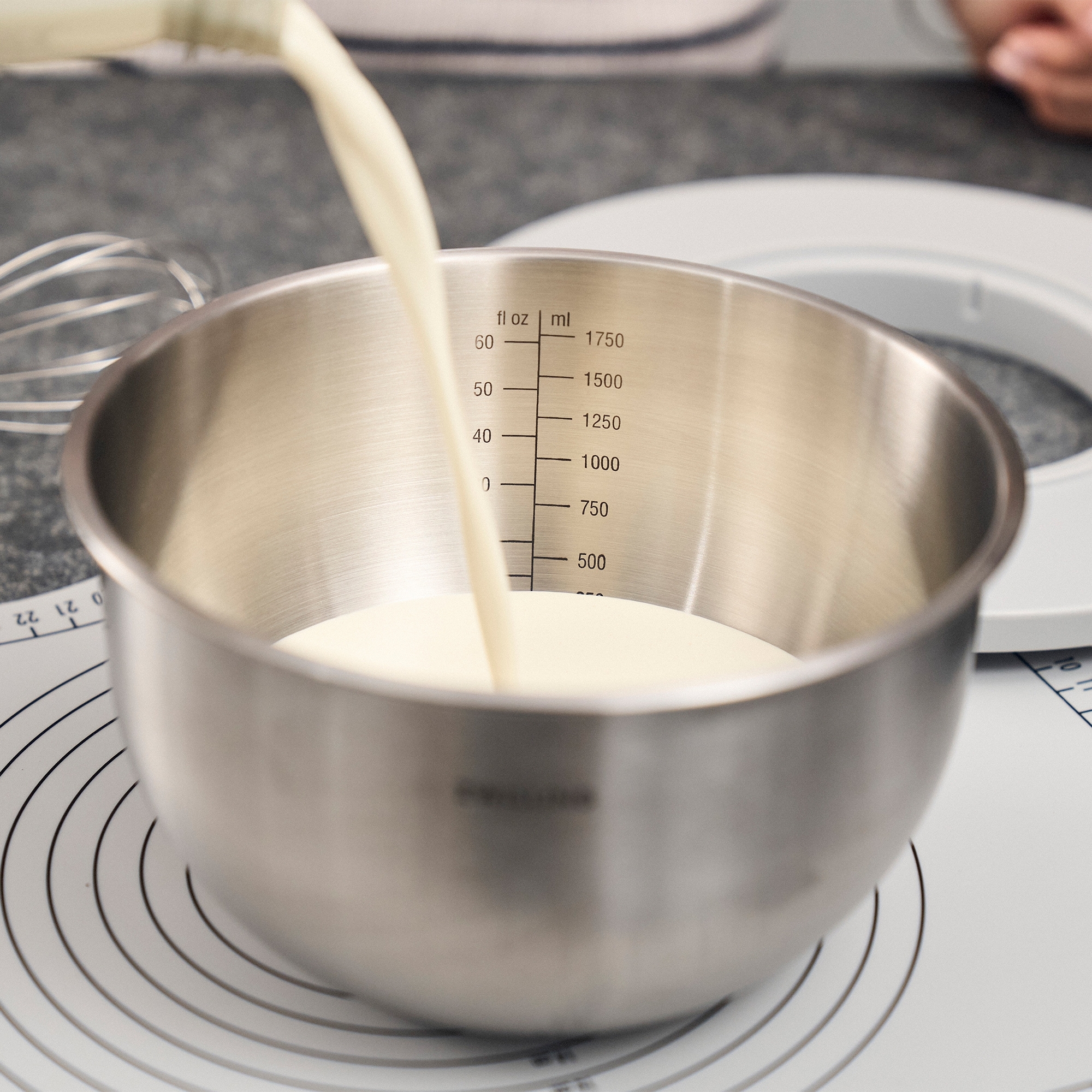 Stainless steel bowl with milk and measuring scale to 1750 m