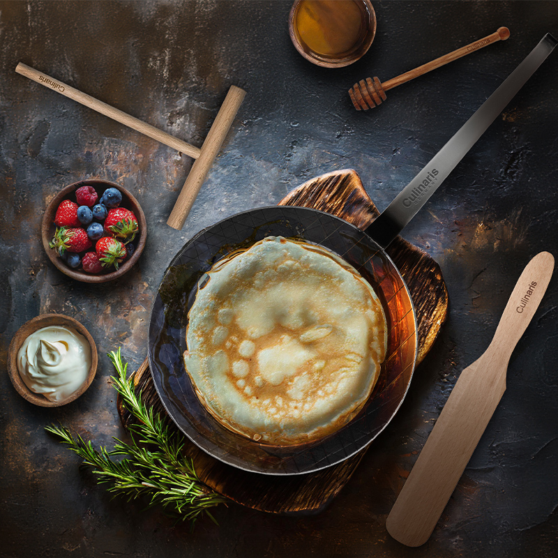 Crepe pan with crepe, berries and honey