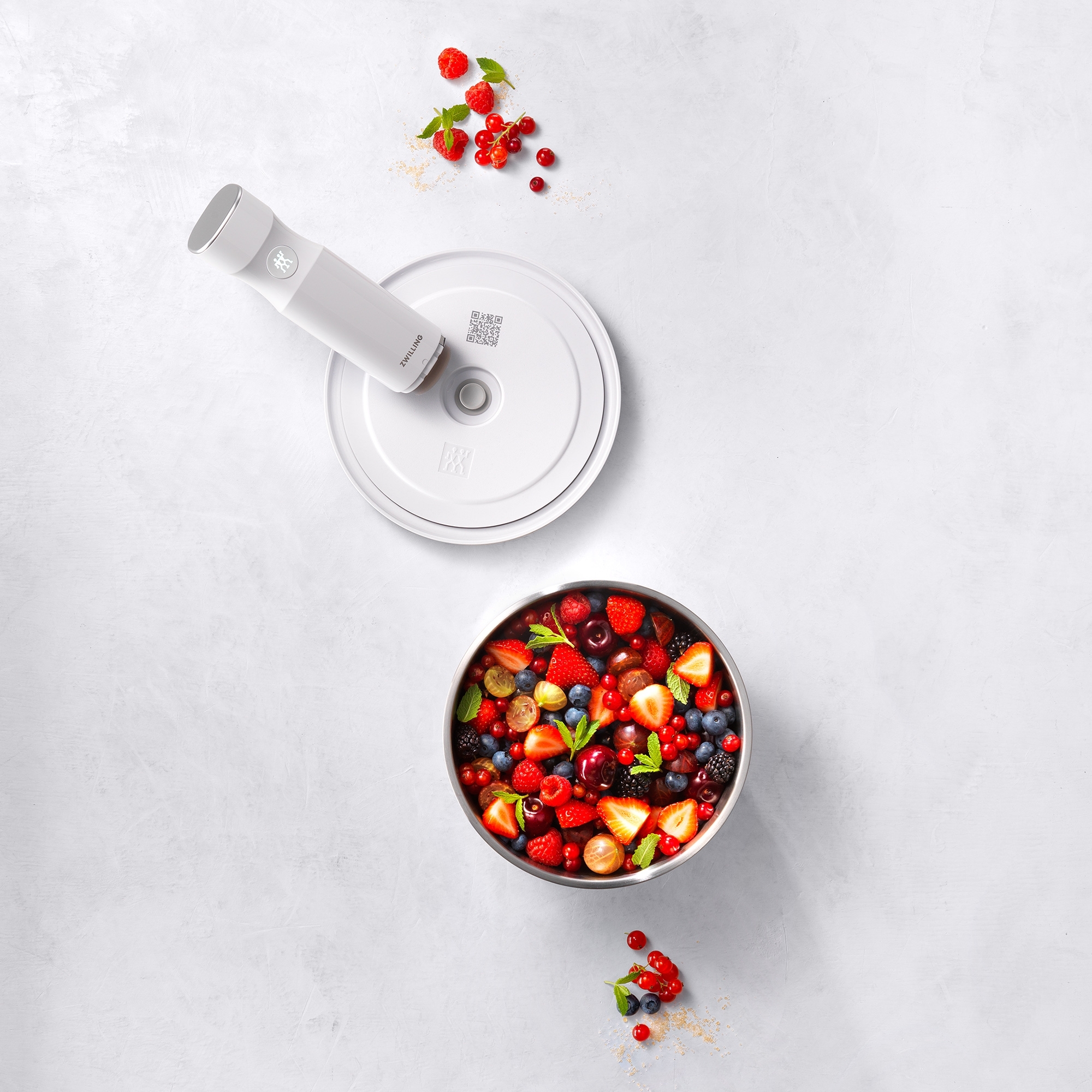 Fresh berries in stainless steel bowl with electric chopper