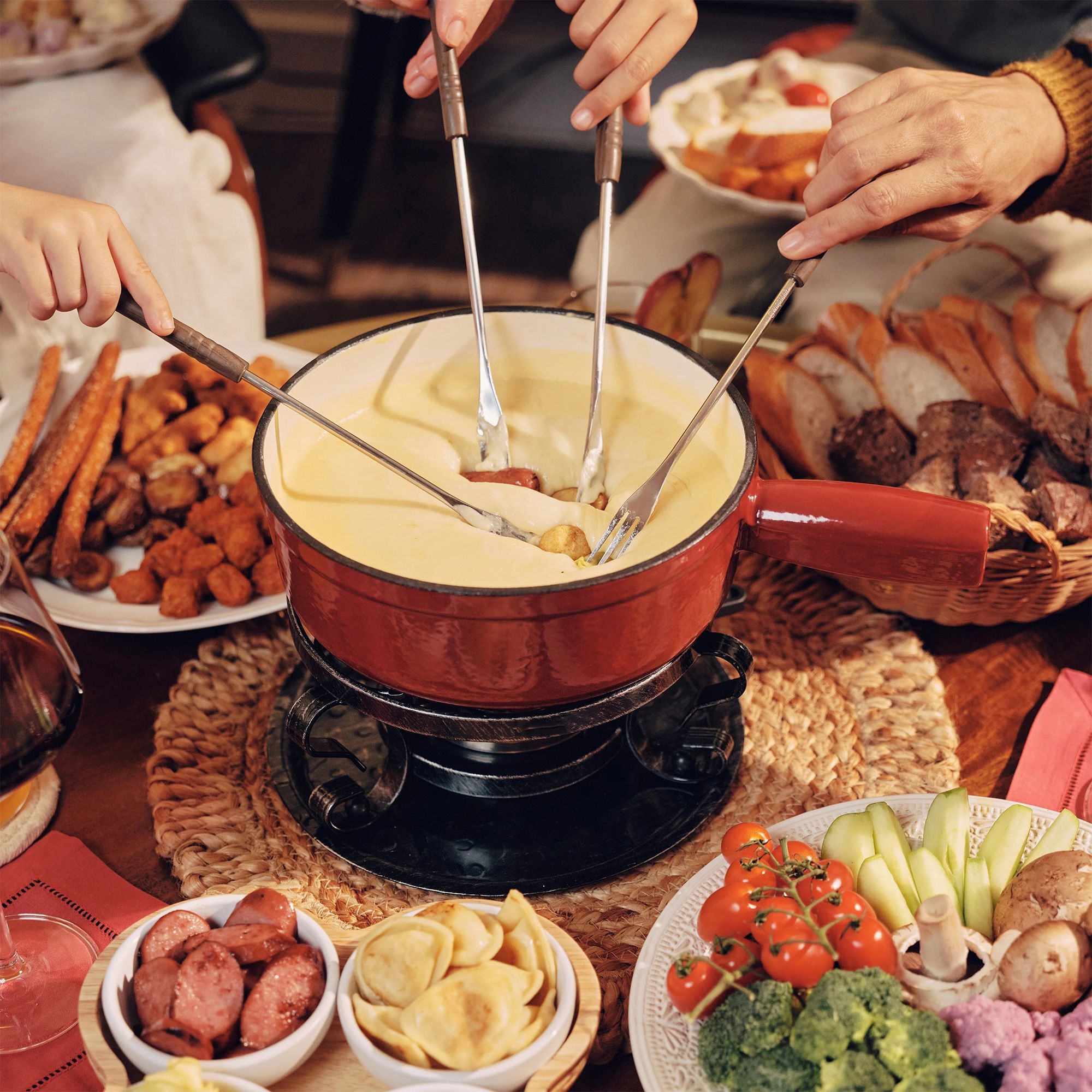 Table with hot cheese fondue and fresh sides
