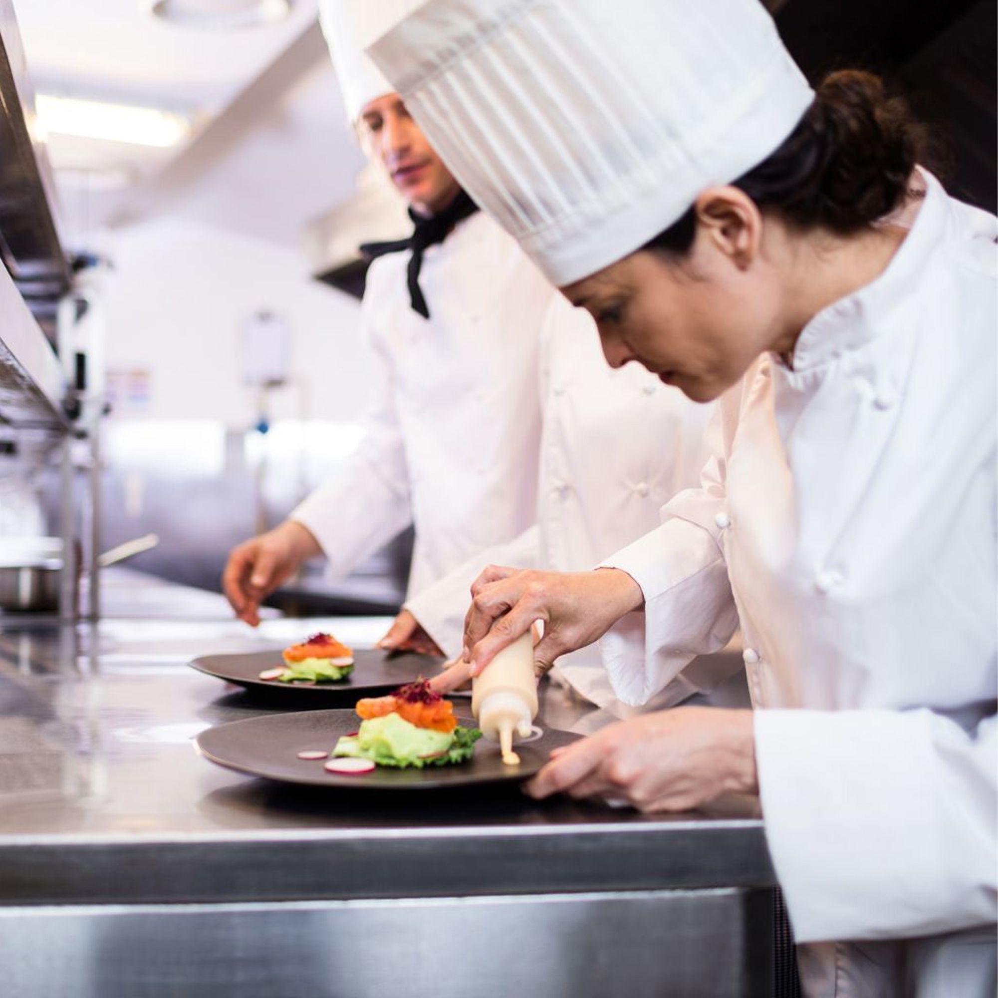 Chef using Westmark squeeze bottle for precise sauce dosing