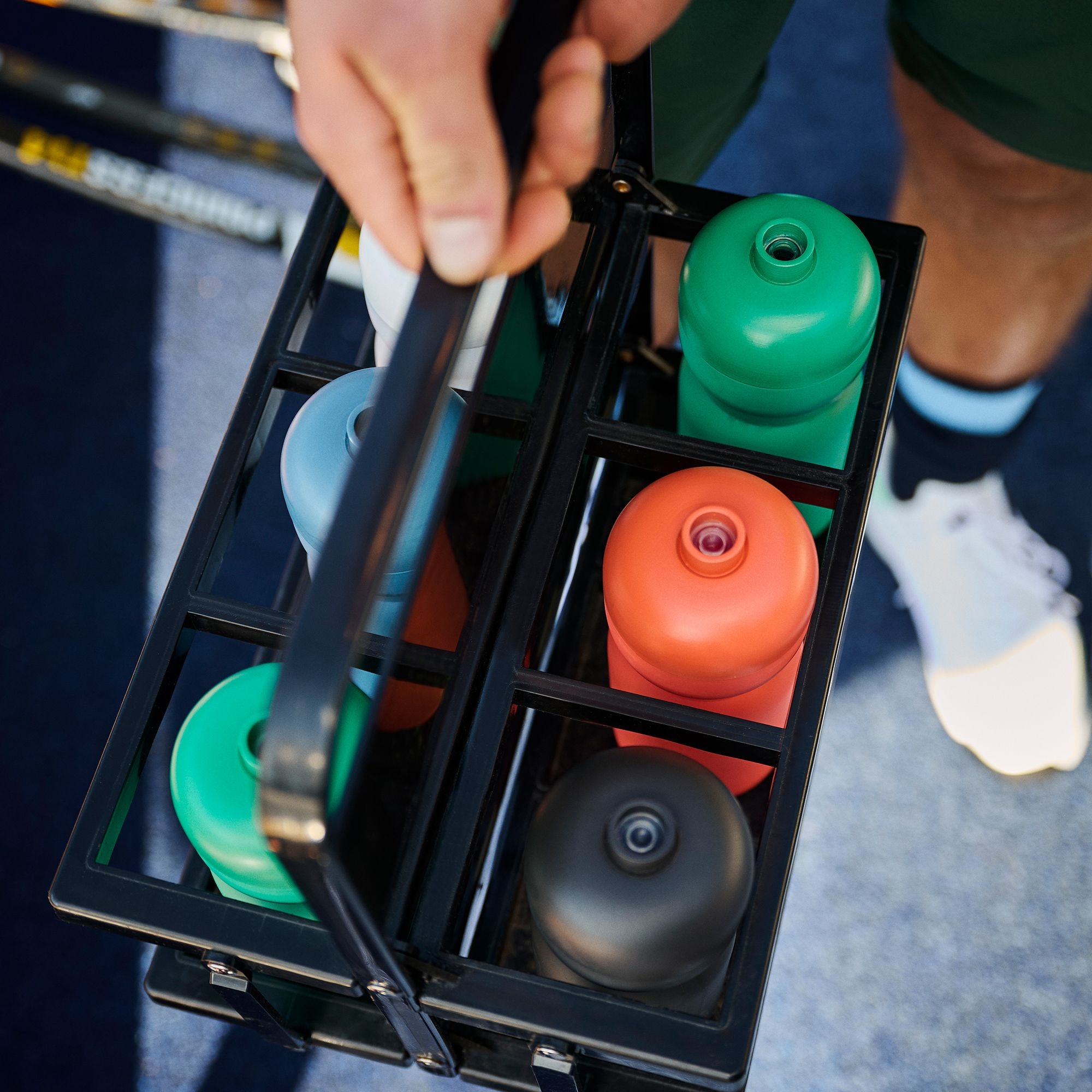 Mehrfarbige Trinkflaschen im tragbaren Flaschenkorb