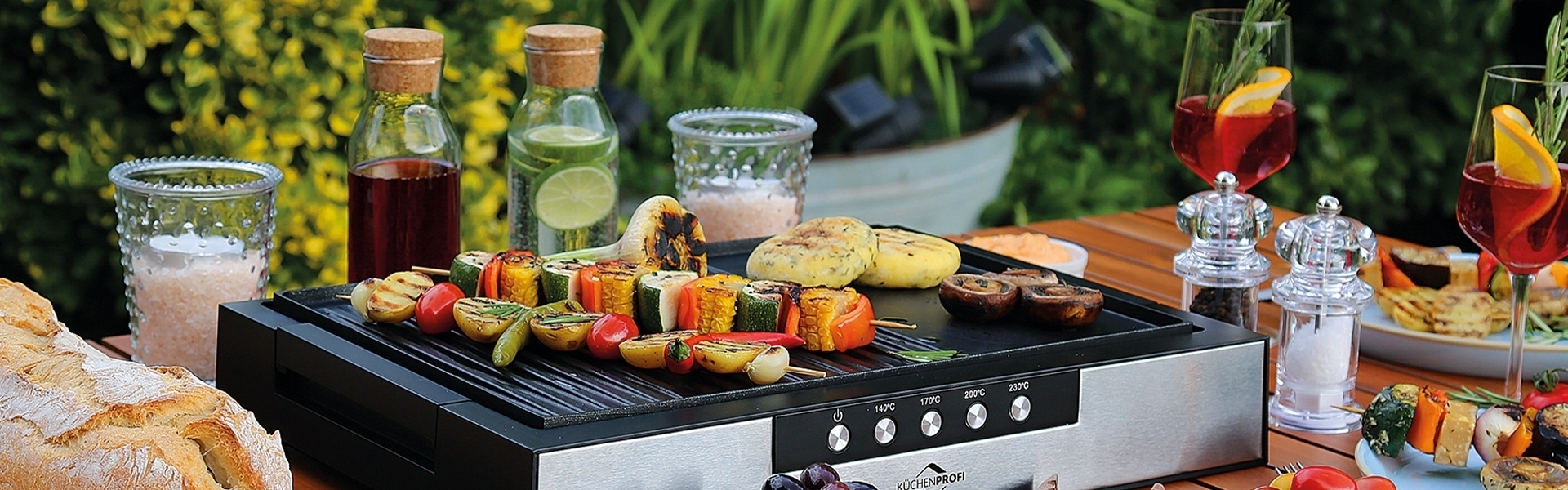 Moderner Tischgrill mit buntem Grillgemüse im Garten