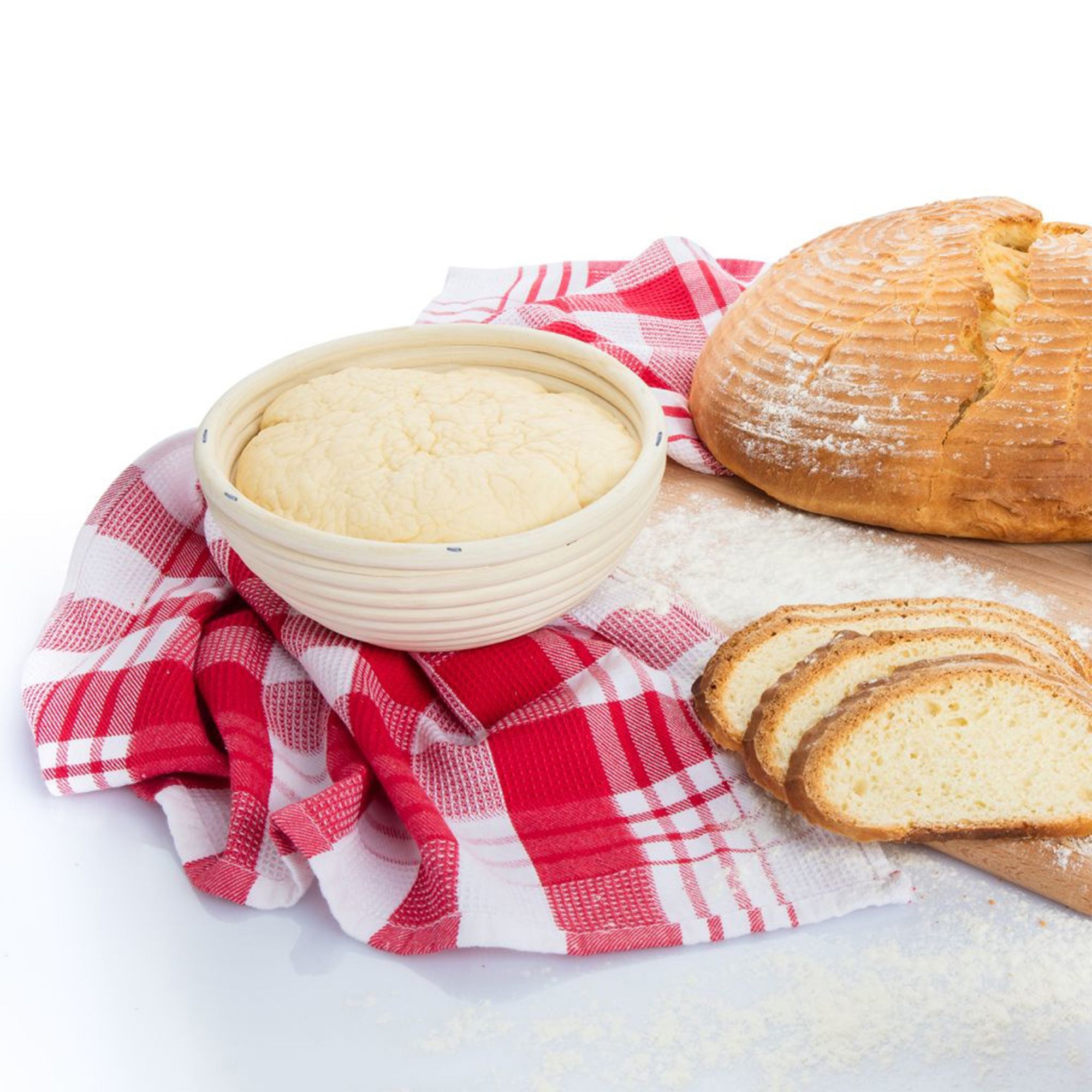 Rundes Gärkörbchen mit Brotteig neben frischem Brot