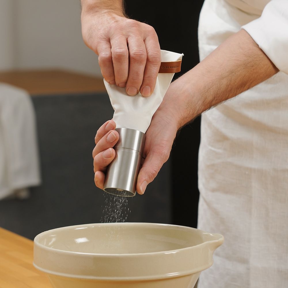 Hand grinding pepper with steel mill into bowl