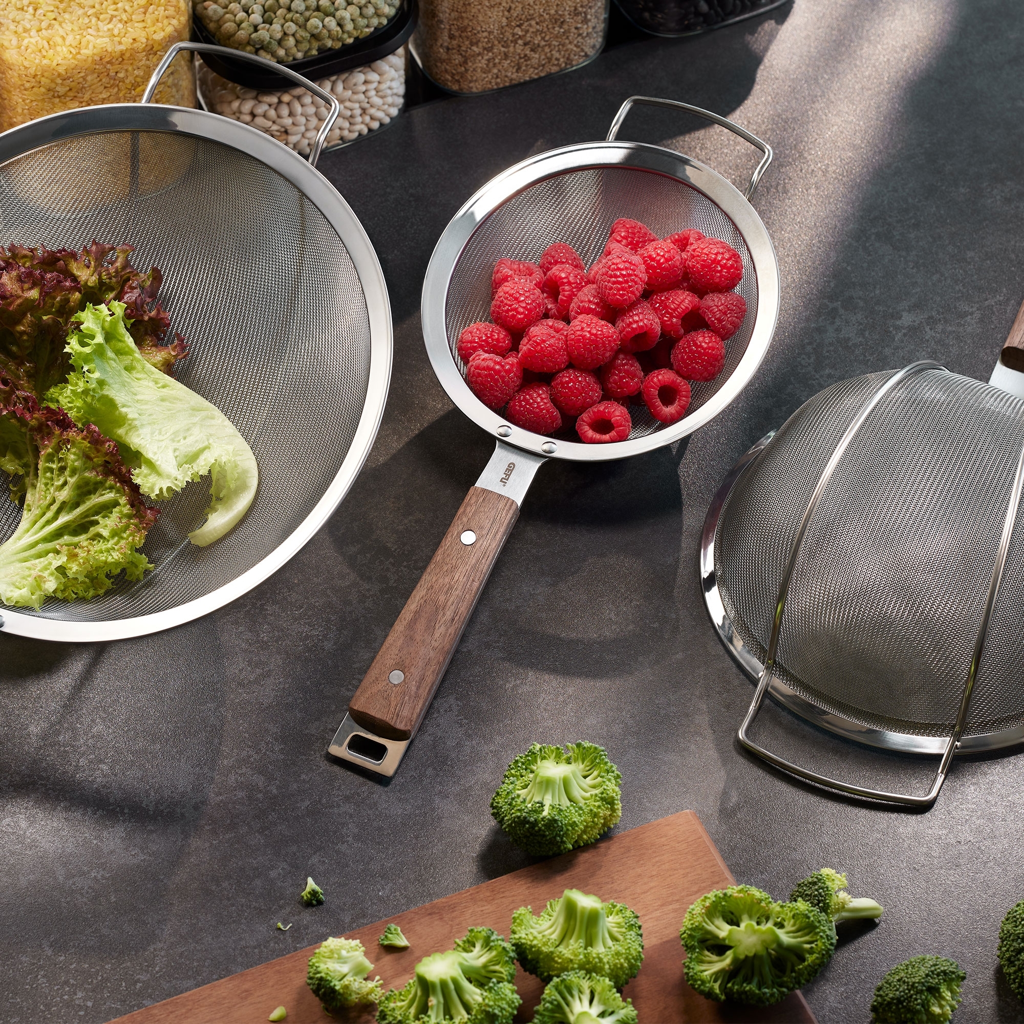 Stainless steel kitchen sieve with wooden handle, raspberrie