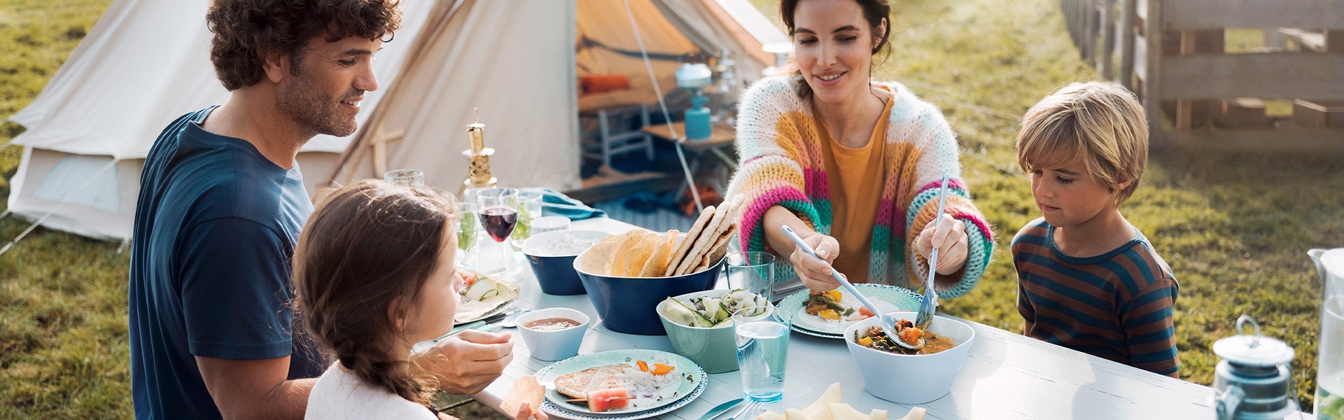 Family sharing a camping meal at the table