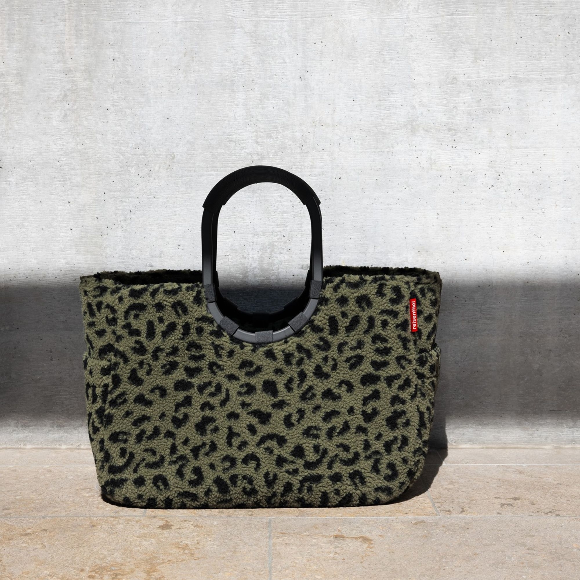 Bag with green leopard pattern and black handles