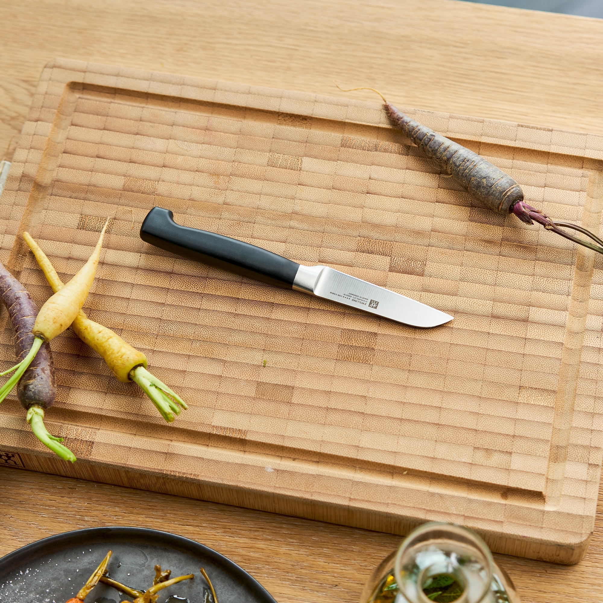 Small vegetable knife on board with carrots