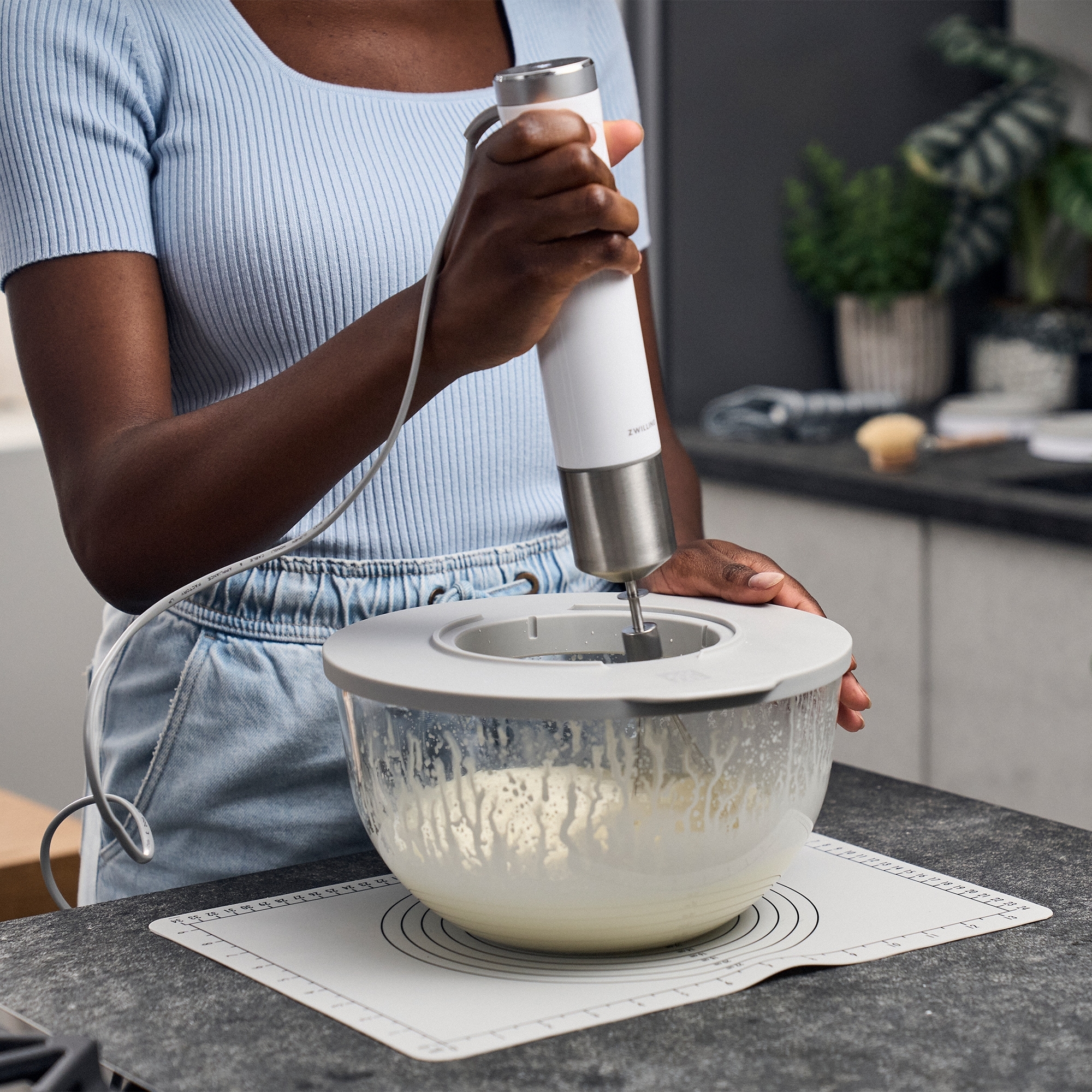 Person mixt Teig mit elektrischem Handmixer in Schüssel