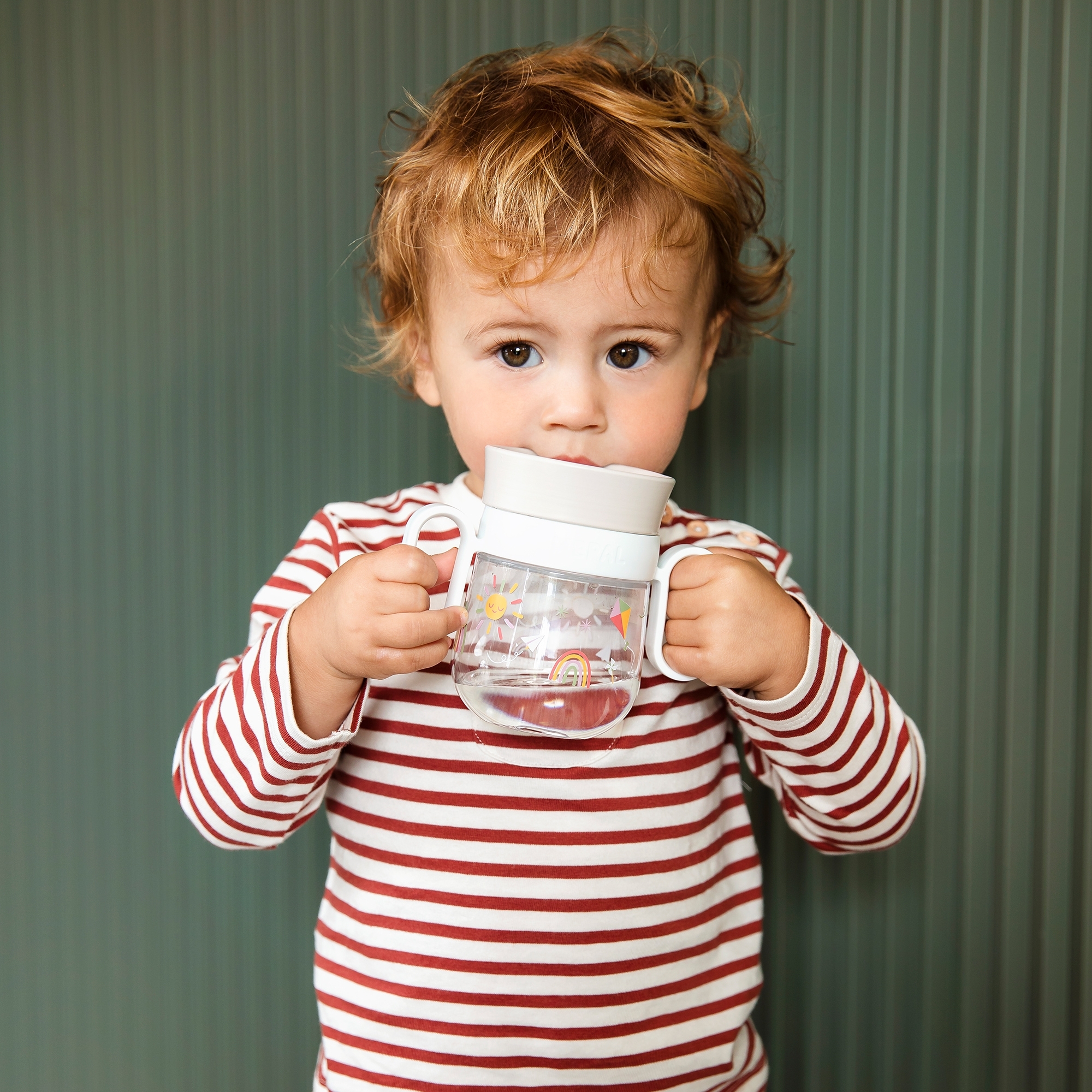 Toddler drinking from Mepal Mio 360° cup sunshine & rainbow