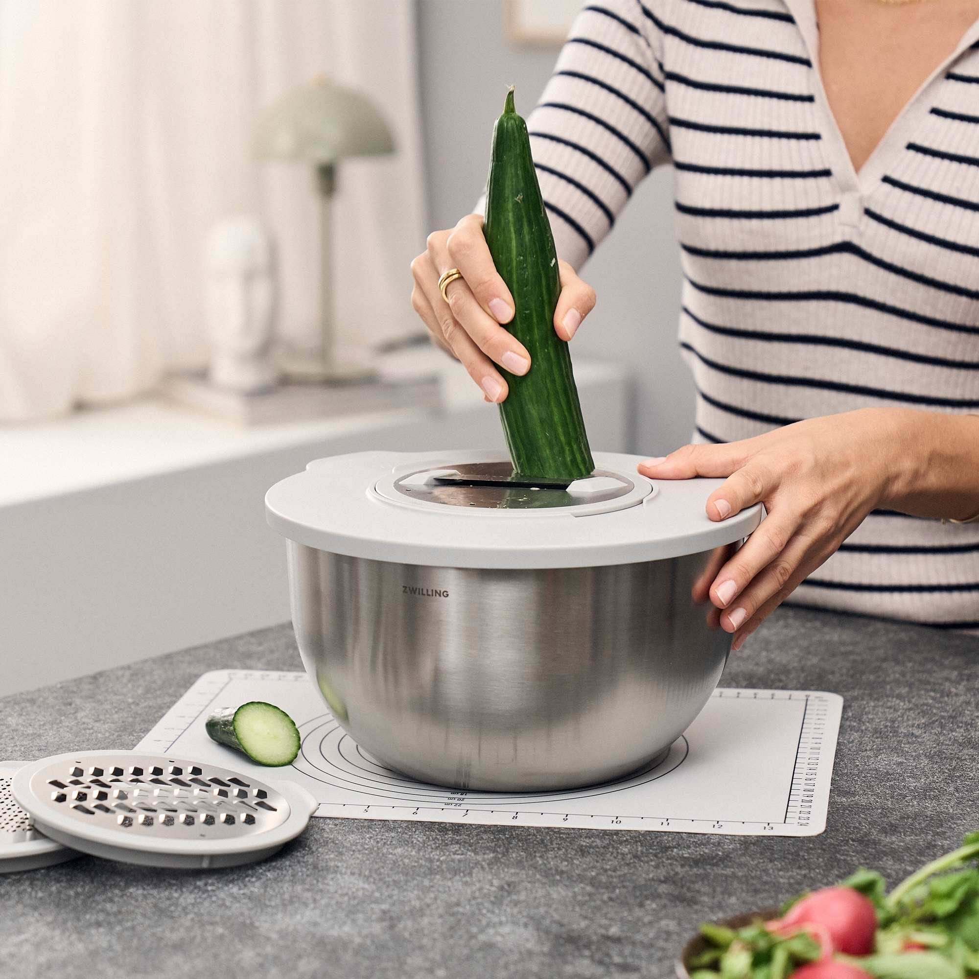 Cucumber being sliced in ZWILLING mixing bowl with lid