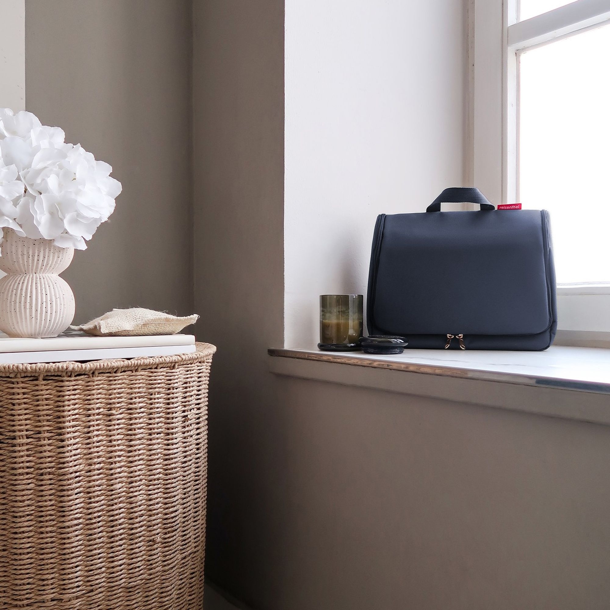 Black cosmetic bag on bathroom windowsill