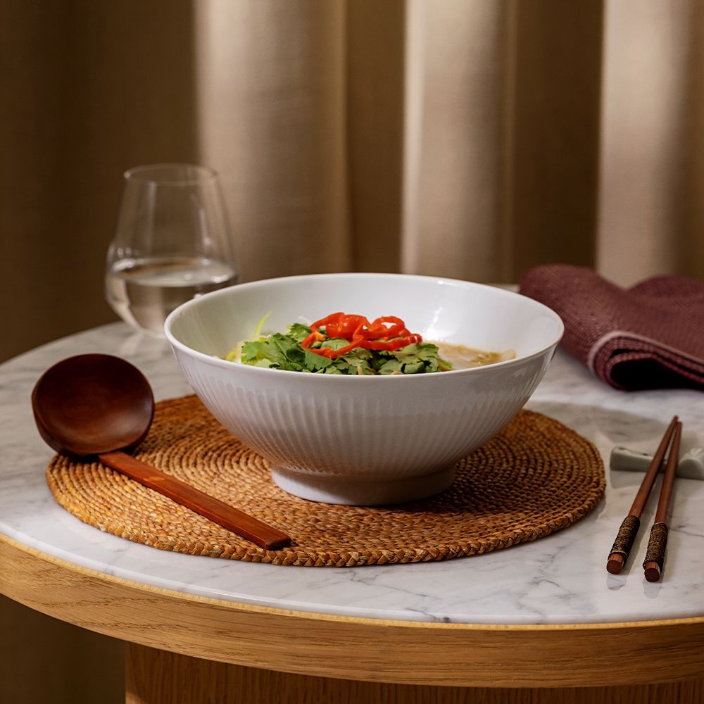Served soup in large white bowl on dining table