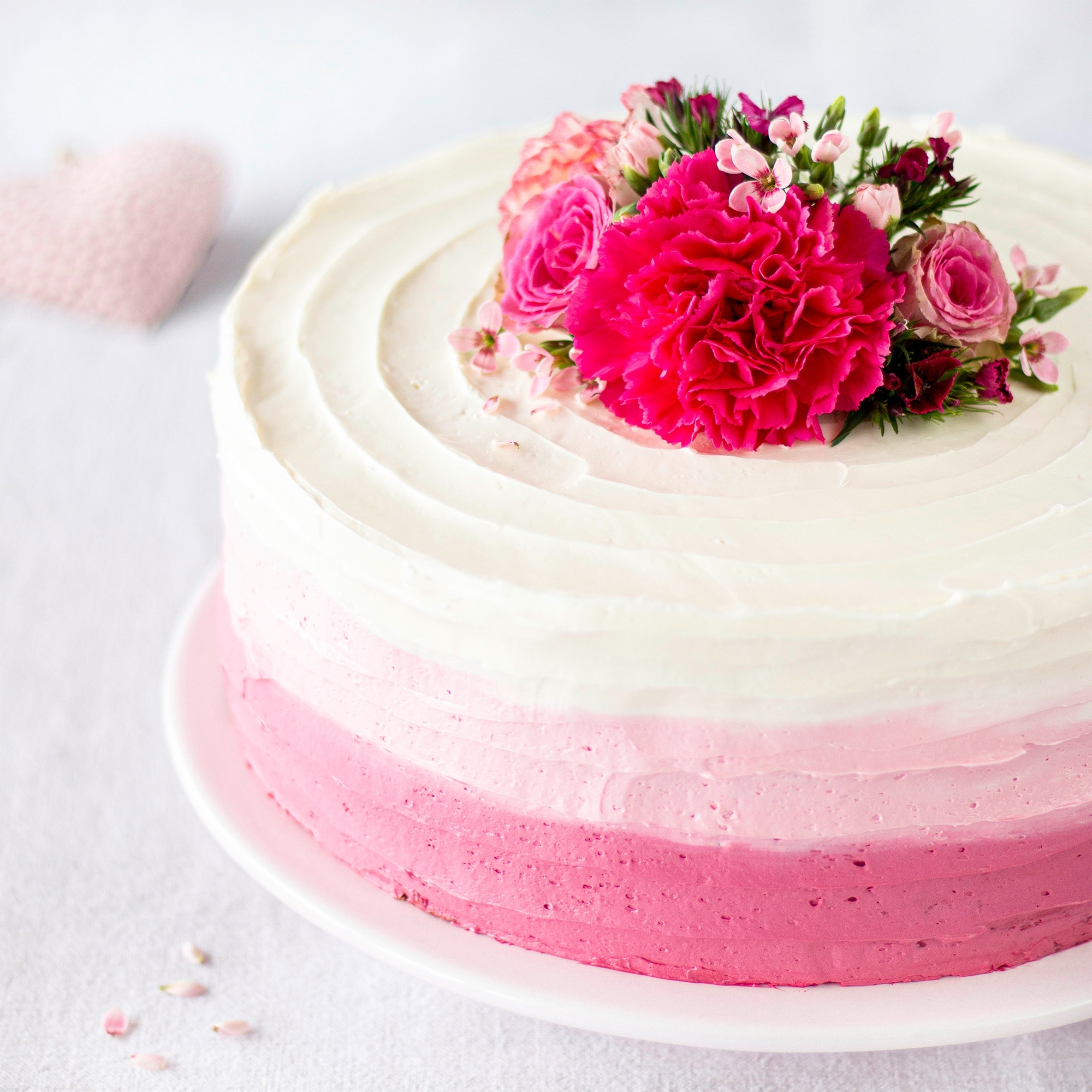 Runde Ombre-Torte mit rosa Buttercreme und Blüten