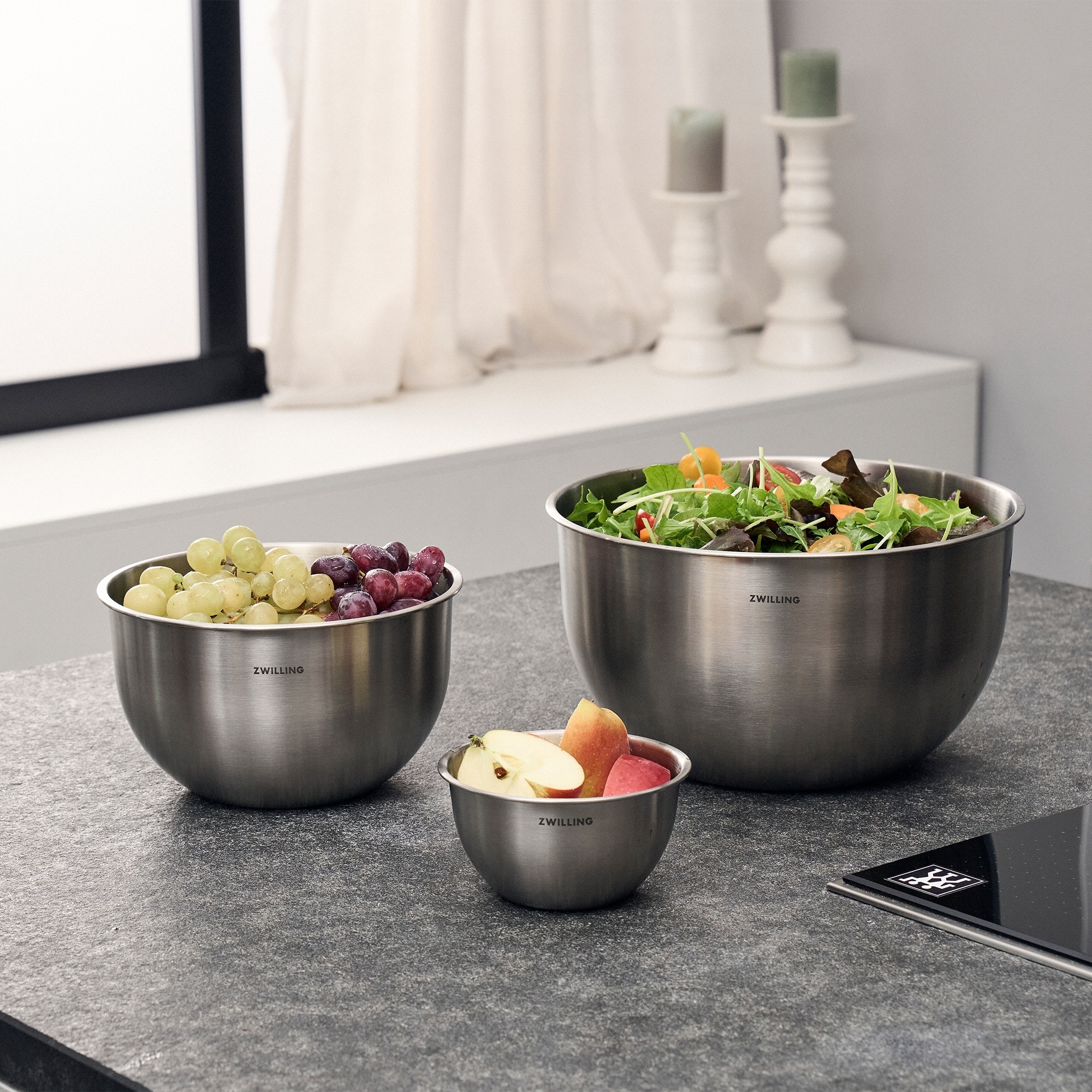 Three stainless steel bowls with fresh fruit and salad
