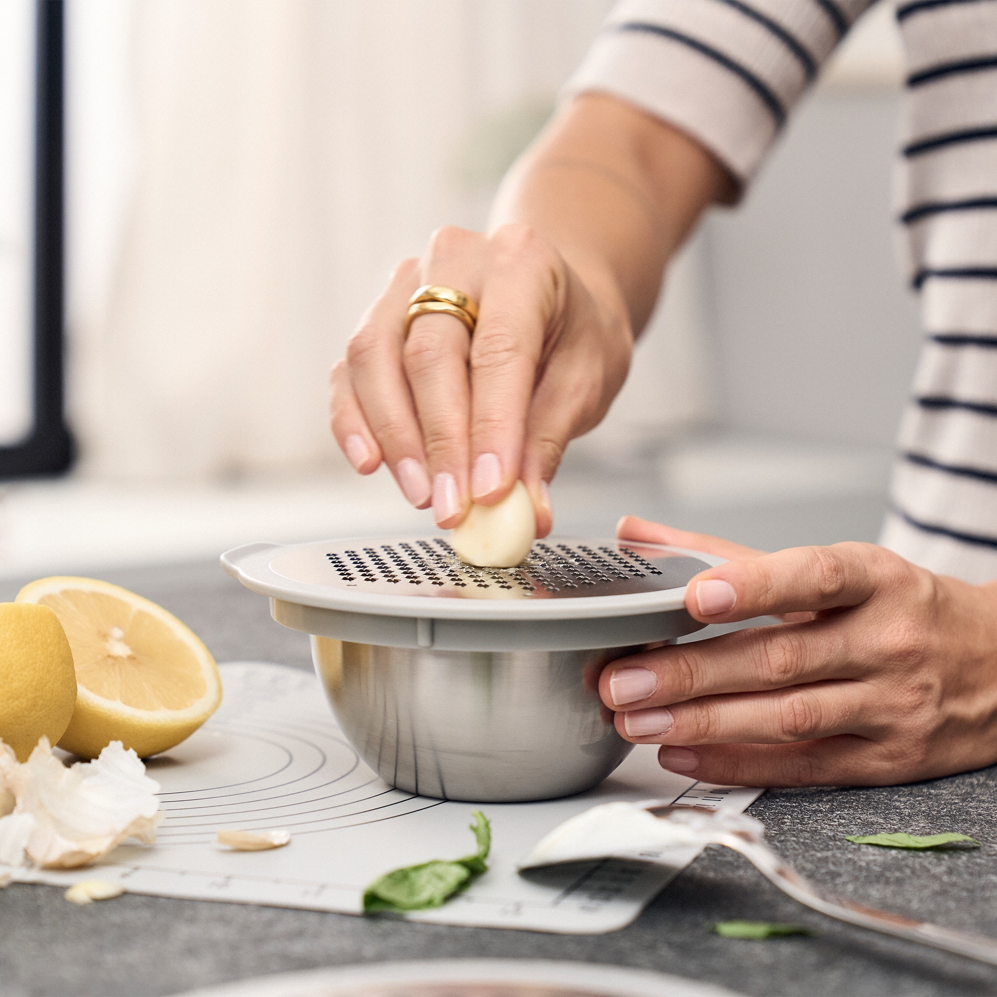 Grating garlic over a stainless steel bowl