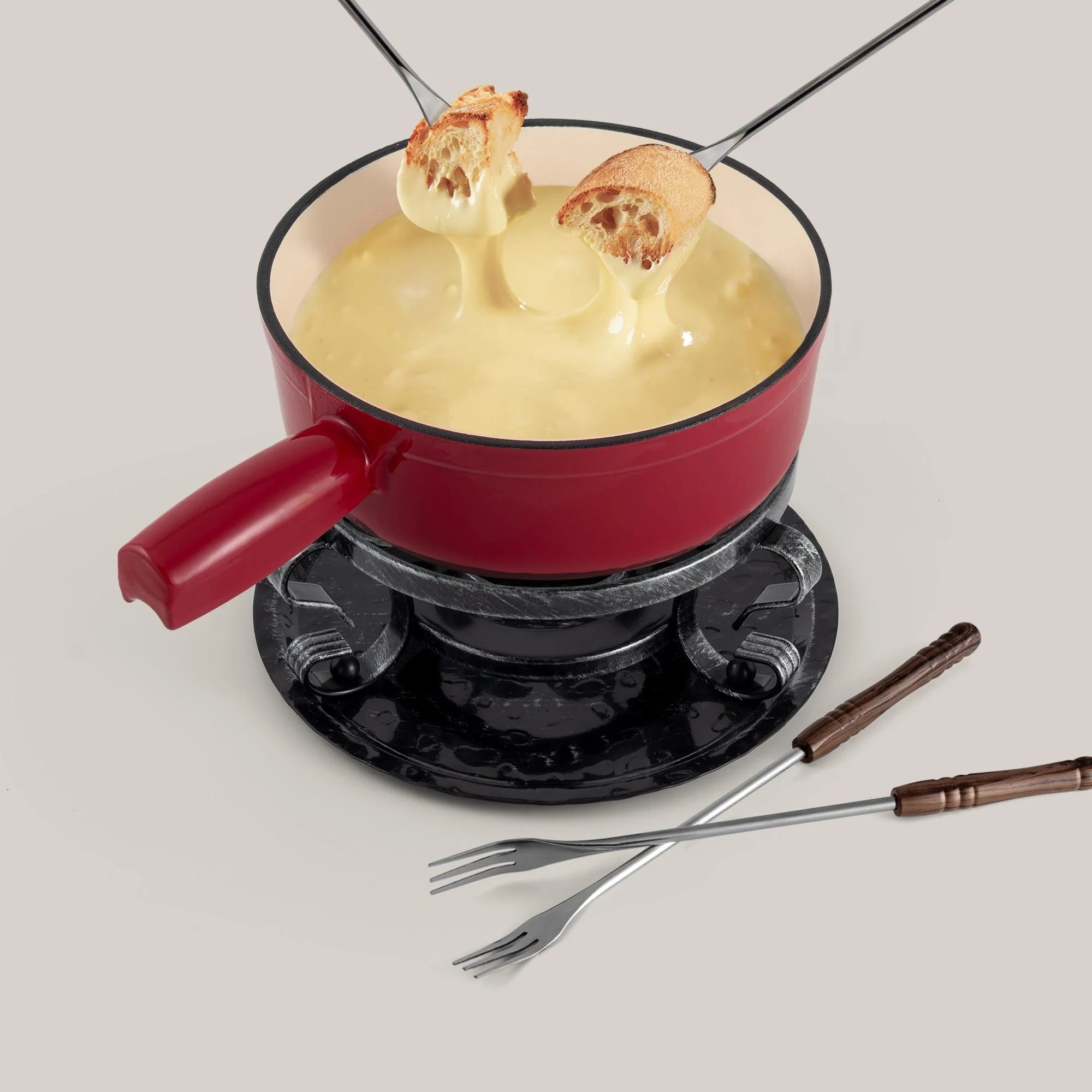Red cheese fondue pot with forks