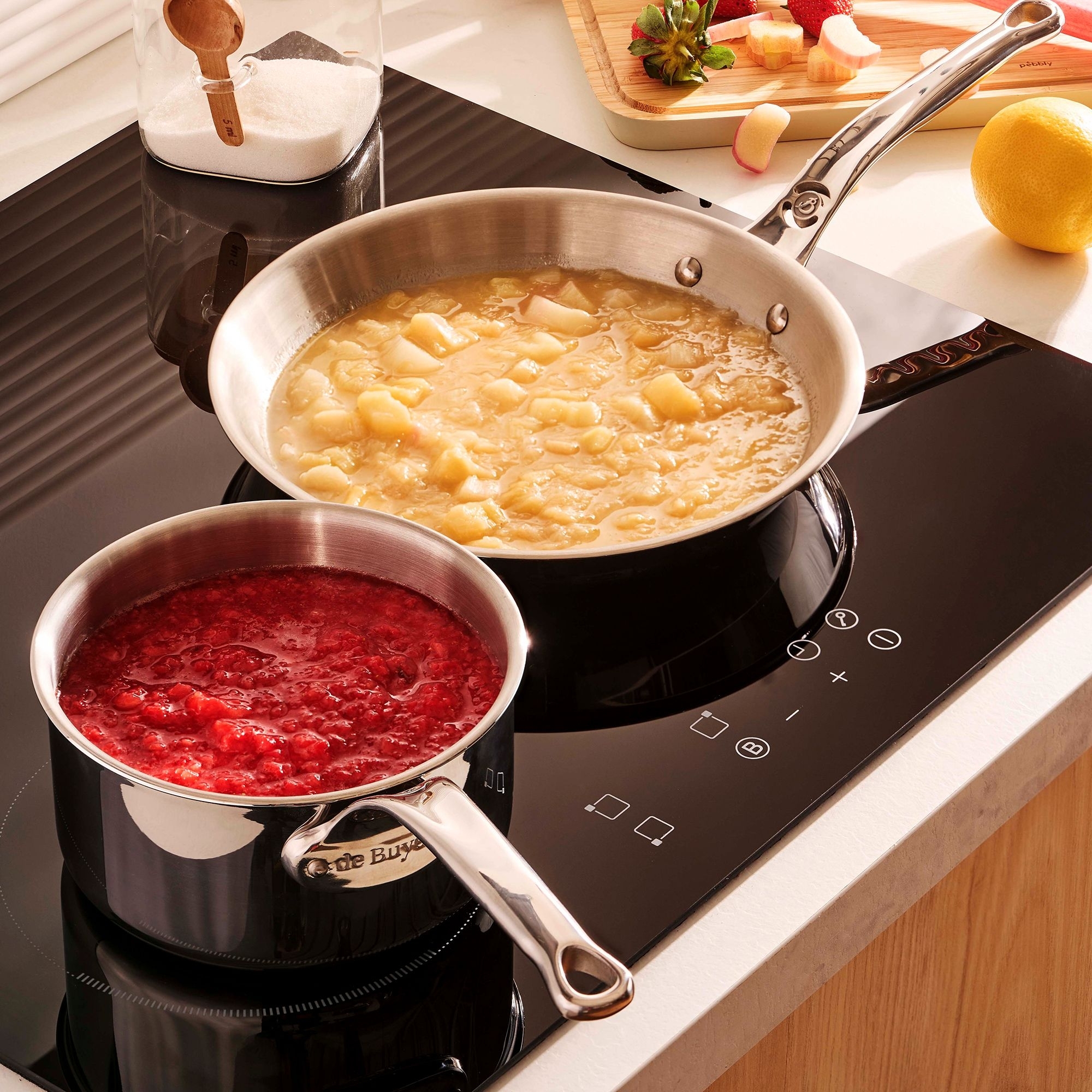 Zwei Edelstahlpfannen auf modernem Induktionskochfeld