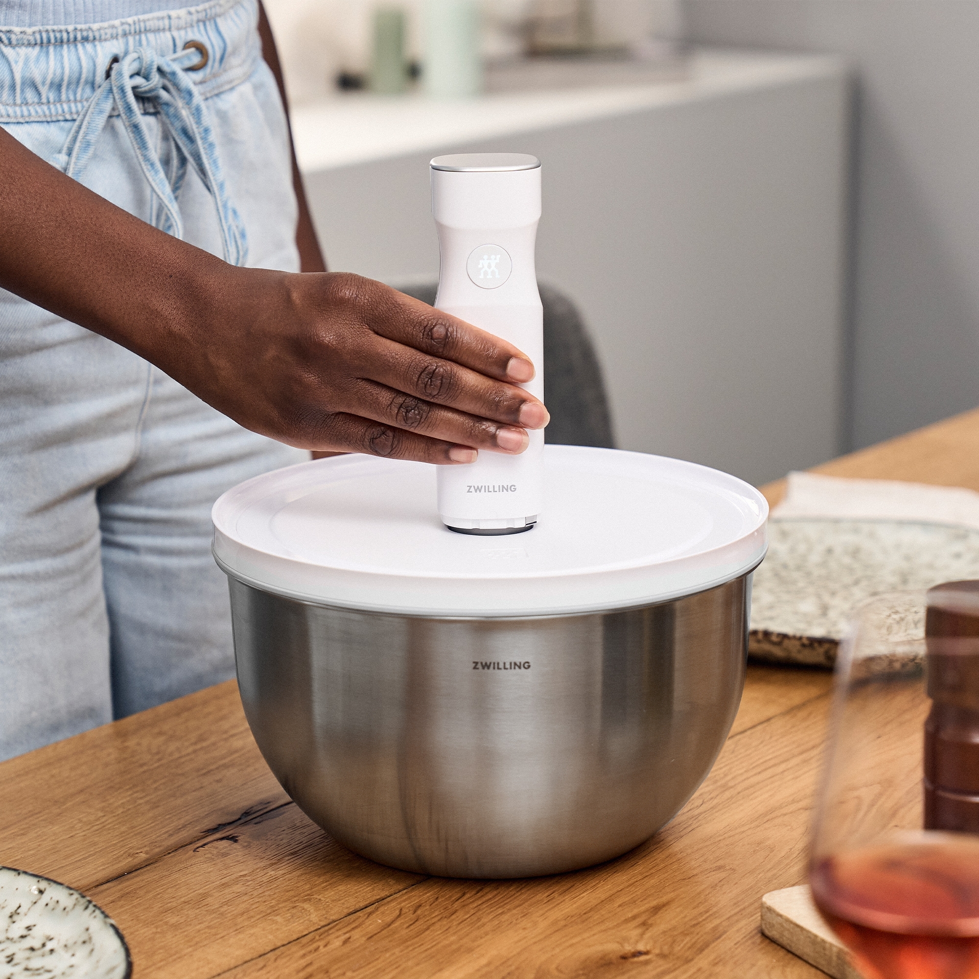 Person uses white Zwilling vacuum lid on bowl