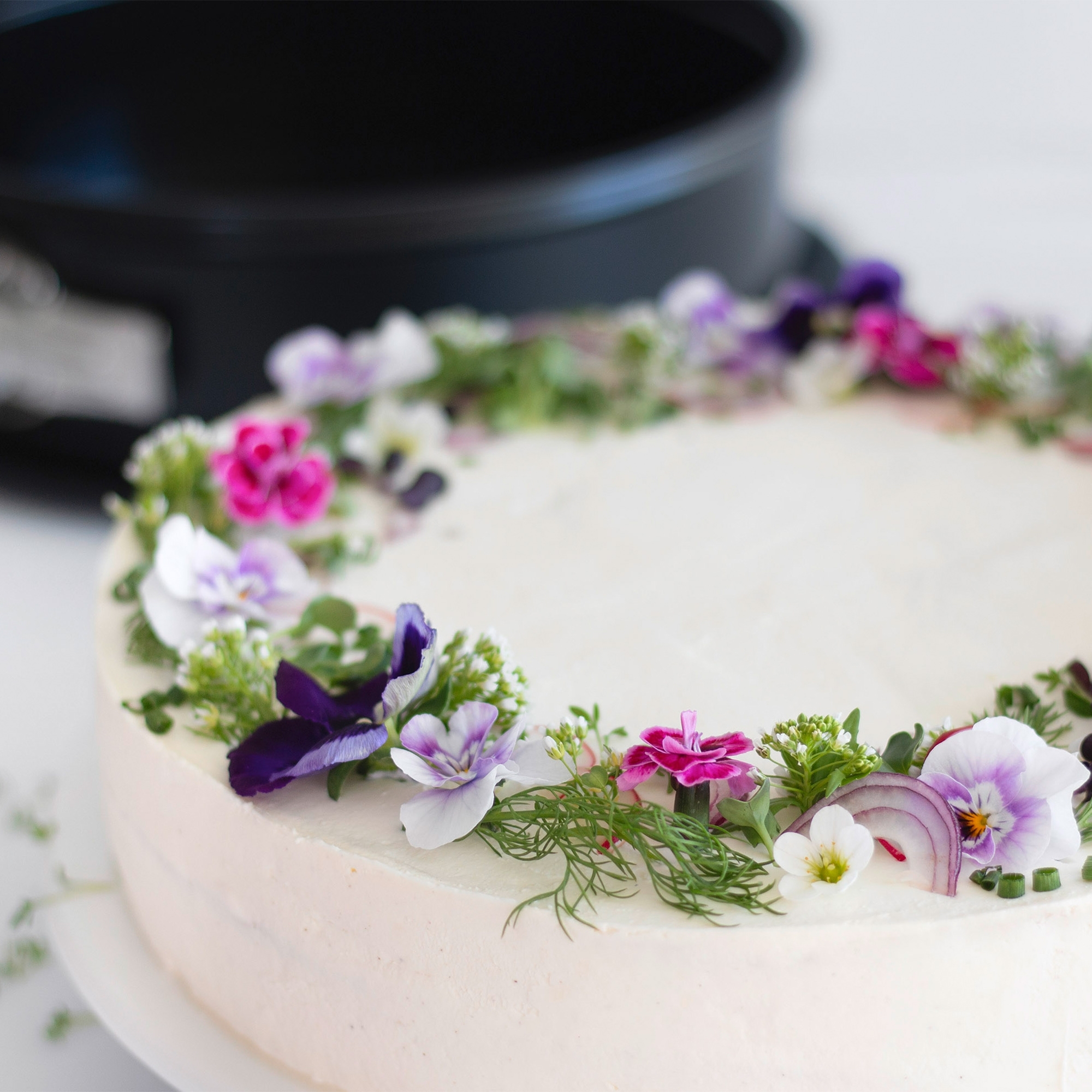 Runde Sahnetorte mit frischen essbaren Blüten