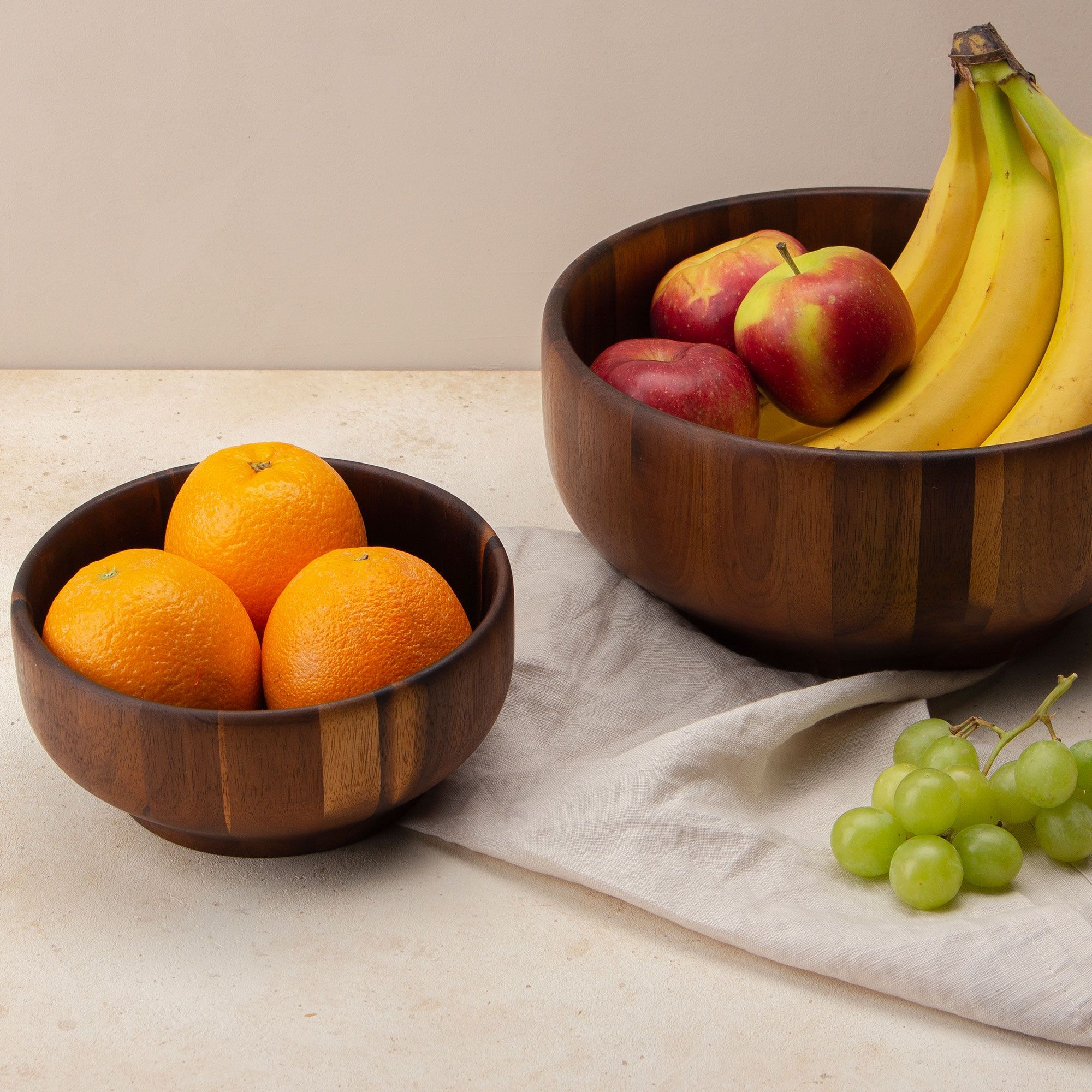 Zwei Holzschalen mit Orangen, Äpfeln, Bananen und Trauben