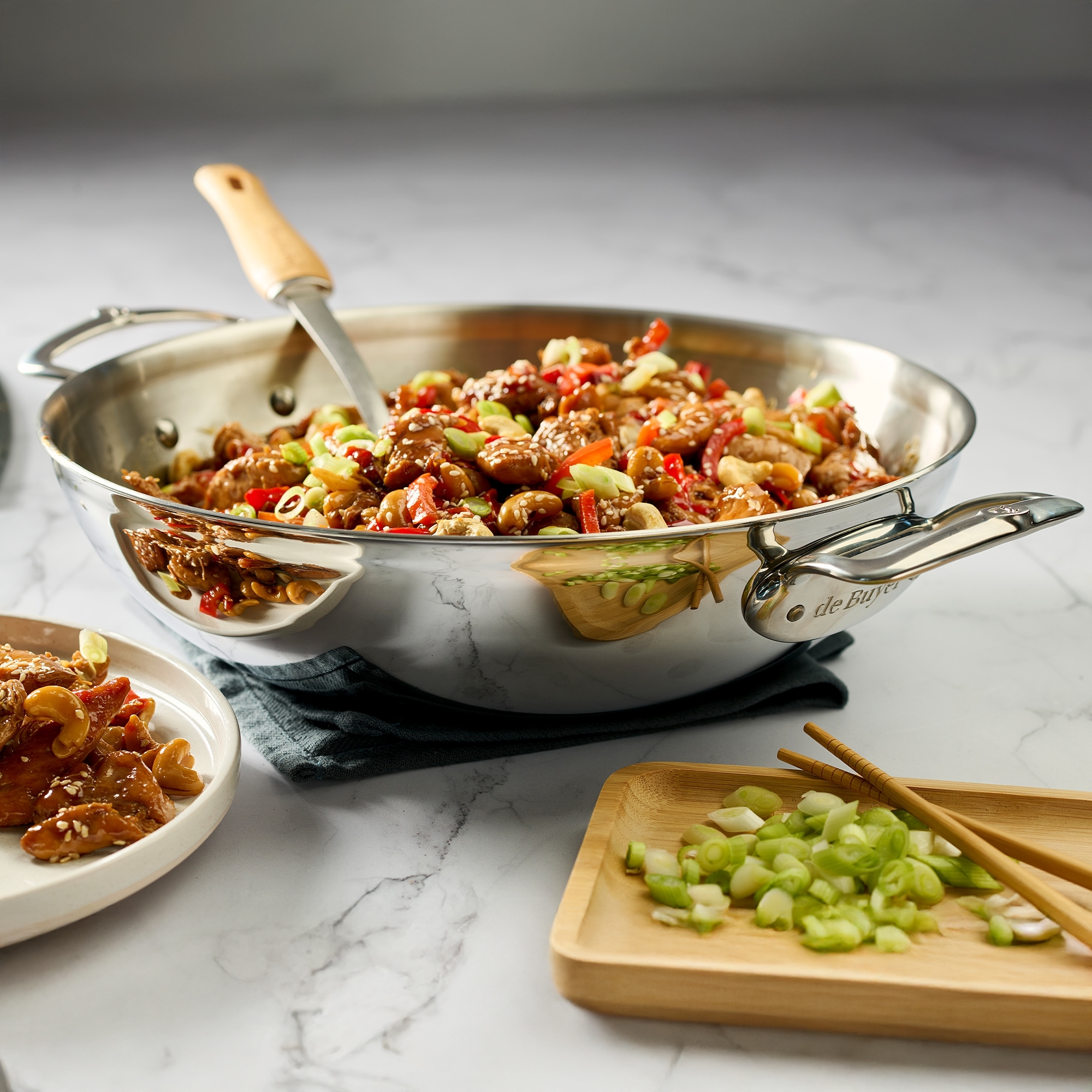 Filled stainless steel wok pan with vegetables, nuts and chi
