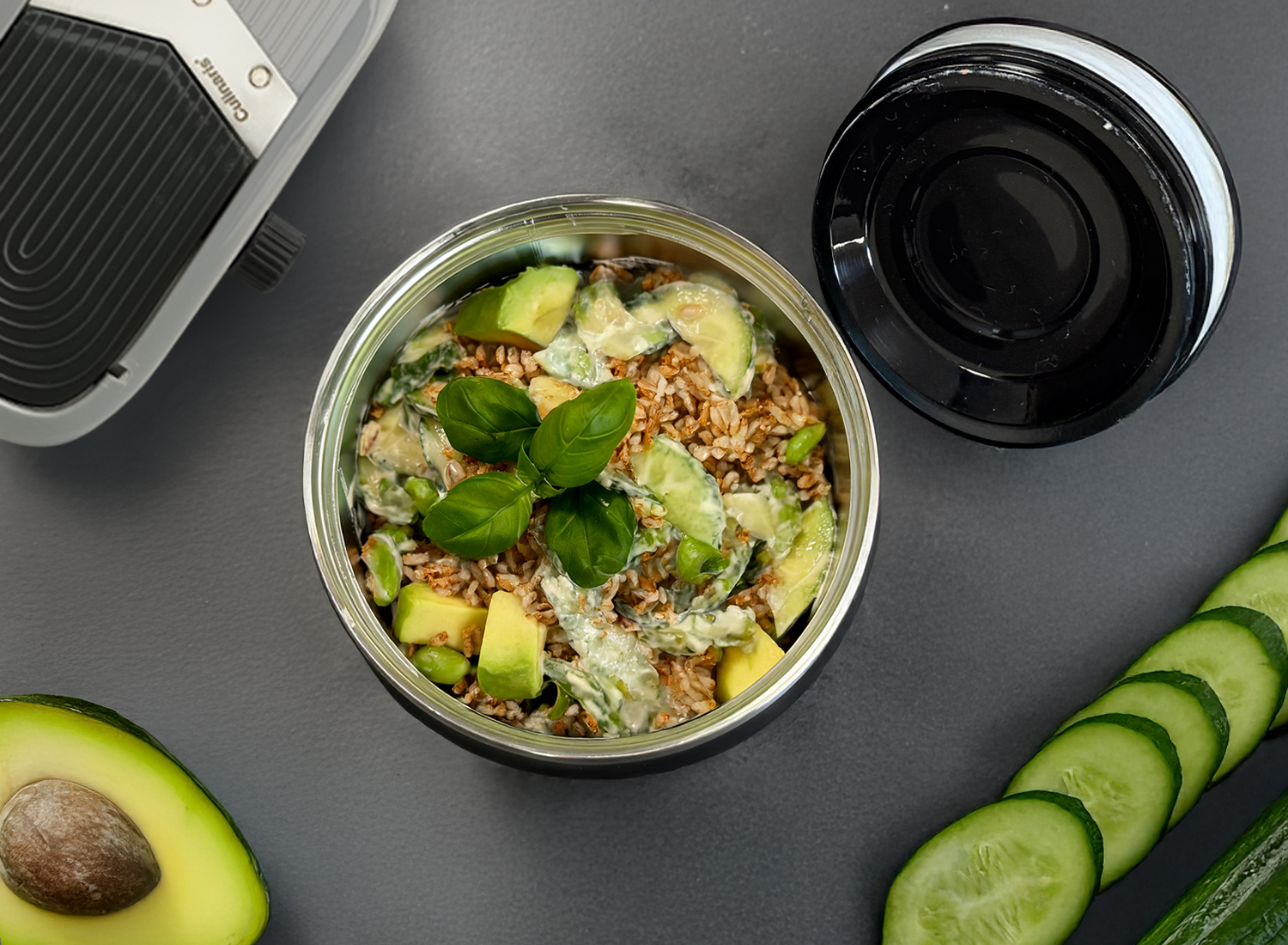 Isolierbehälter mit Avocado-Gurkensalat und Getreide