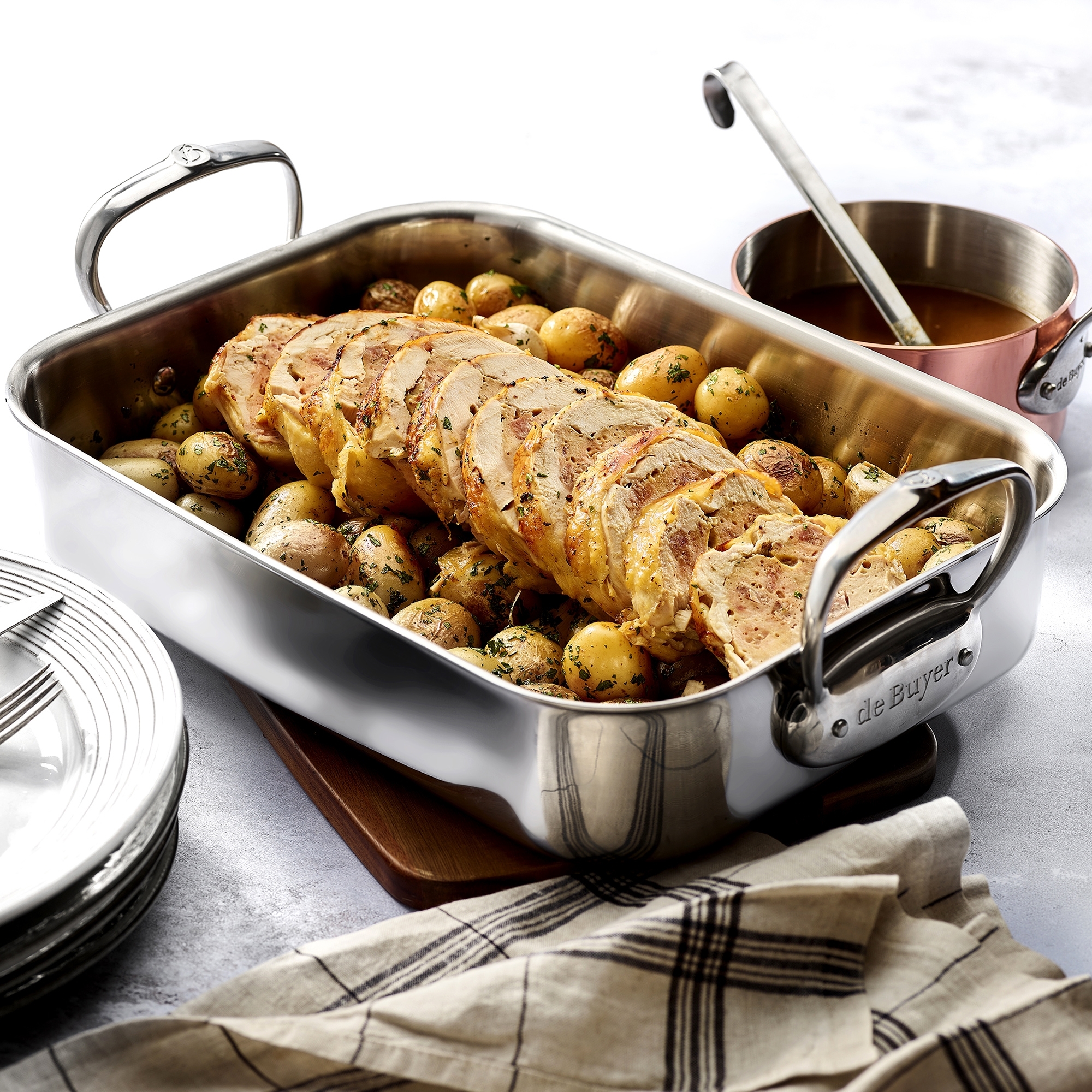 Oven-safe stainless steel roaster with roast and potatoes