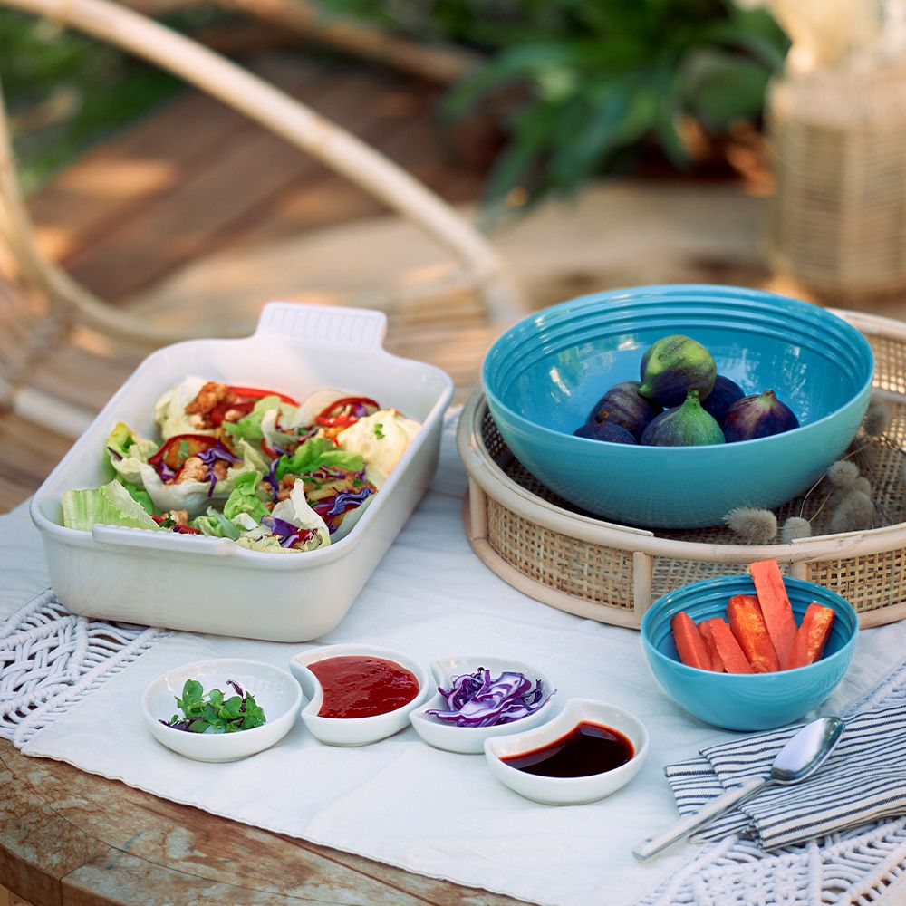 Bowls with salad, figs, carrots and various dips