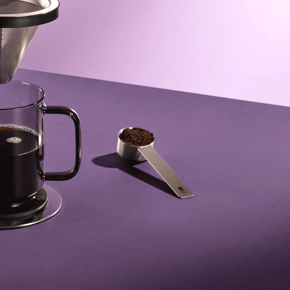AdHoc Moro stainless steel coffee scoop with ground coffee