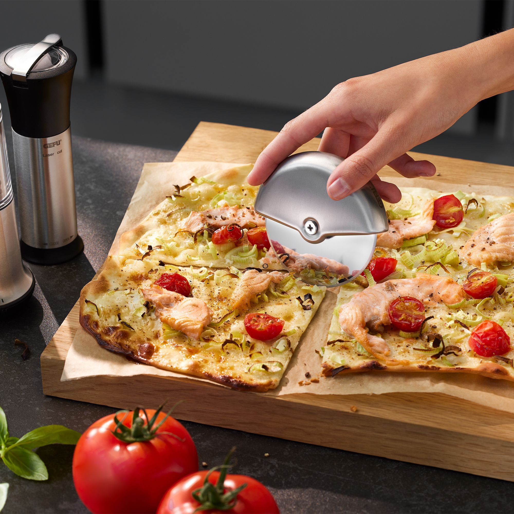 Hand cutting tarte flambée with round stainless steel pizza