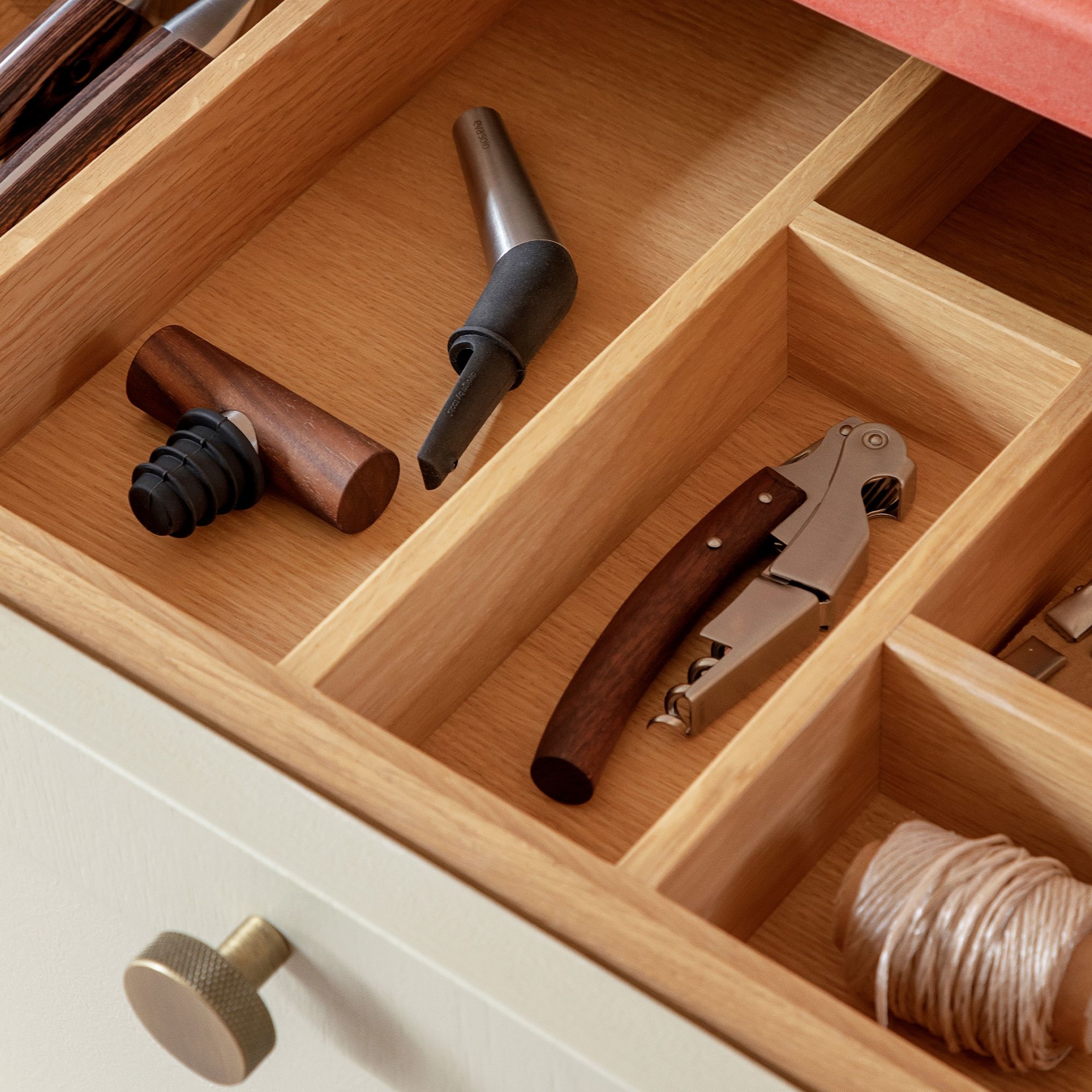 Offene Schublade mit Holz-Besteckkasten und Weinset