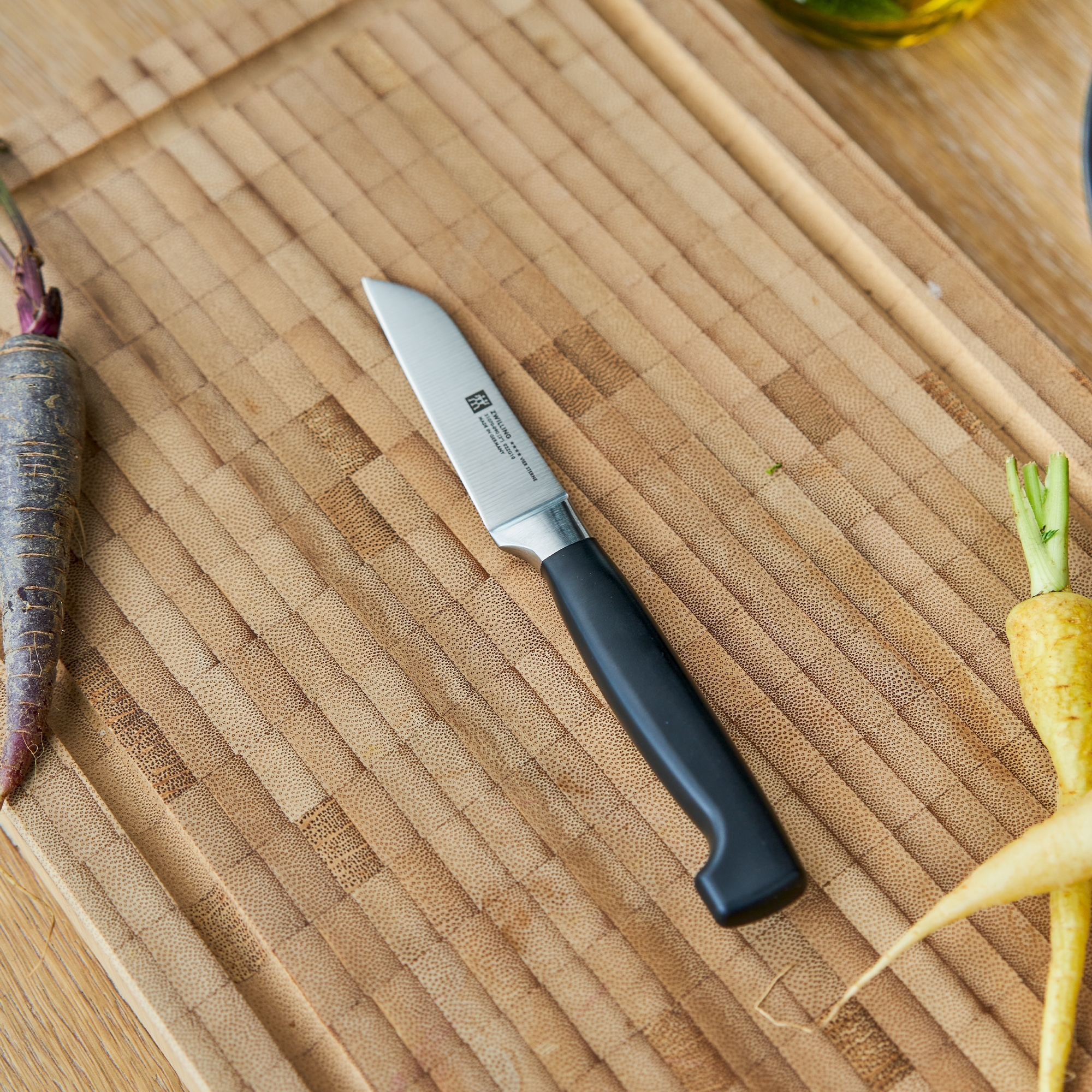 Chef’s knife with black handle on chopping board