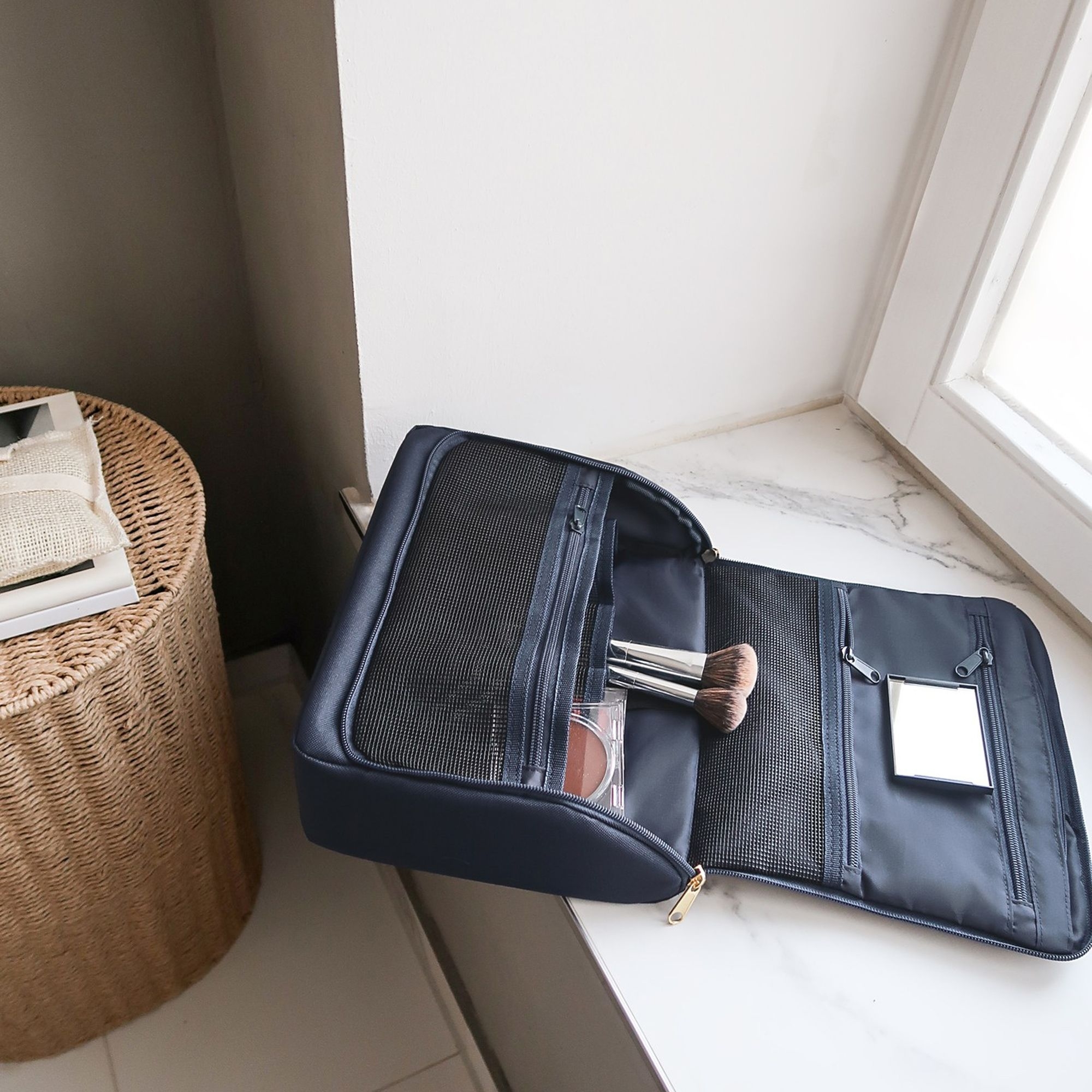 Open navy cosmetic bag with makeup items