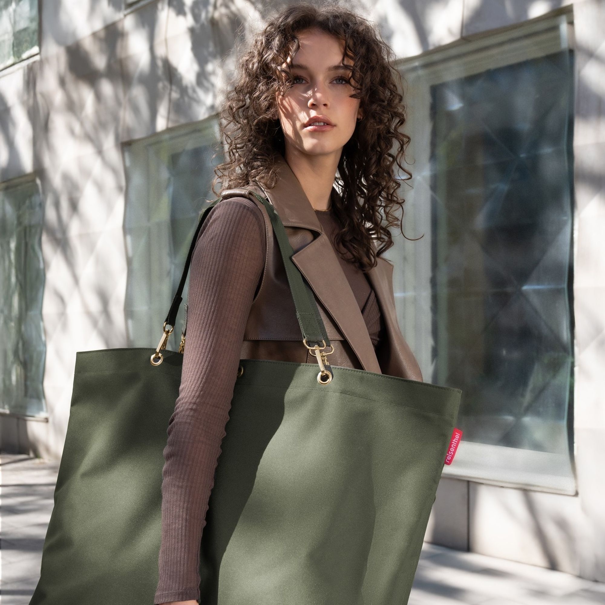 Woman carrying large olive green shopper bag