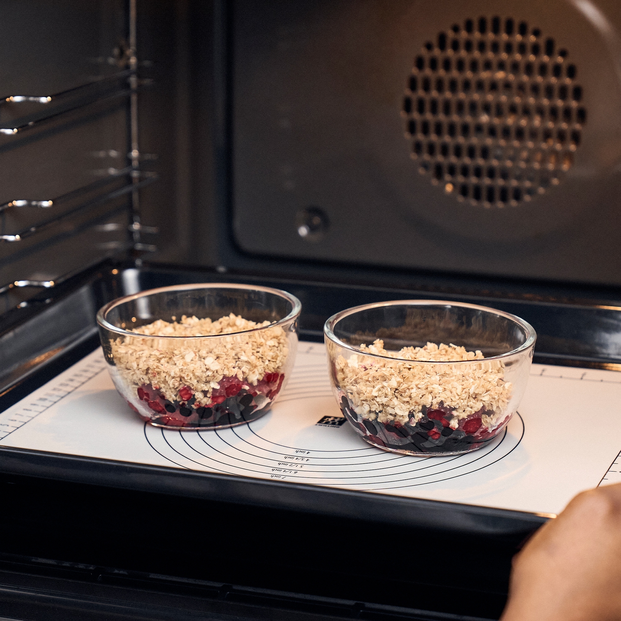 Glasformen mit Obst und Haferflocken im Ofen