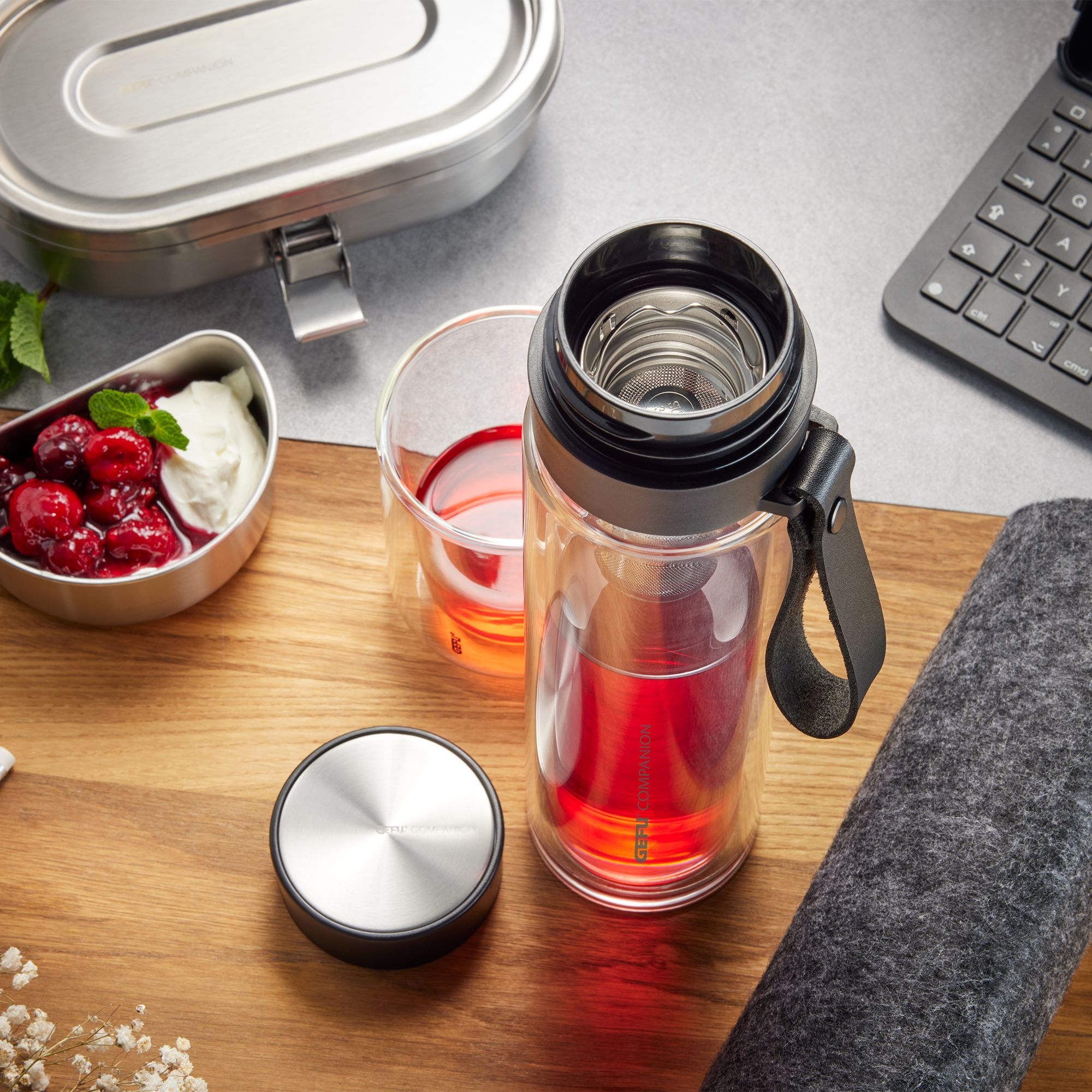 Clear tea bottle with infuser, lid and hot drink