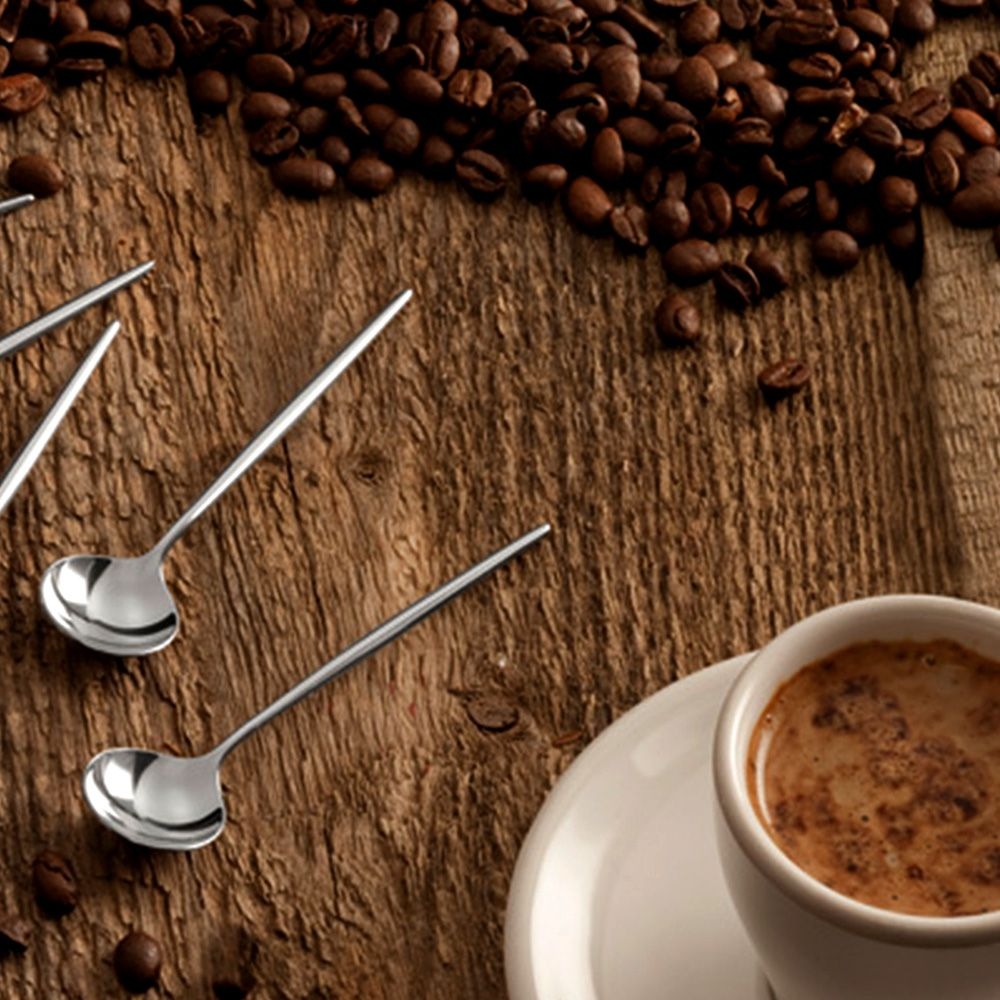 Edelstahl-Espressolöffel neben Tasse und Kaffeebohnen