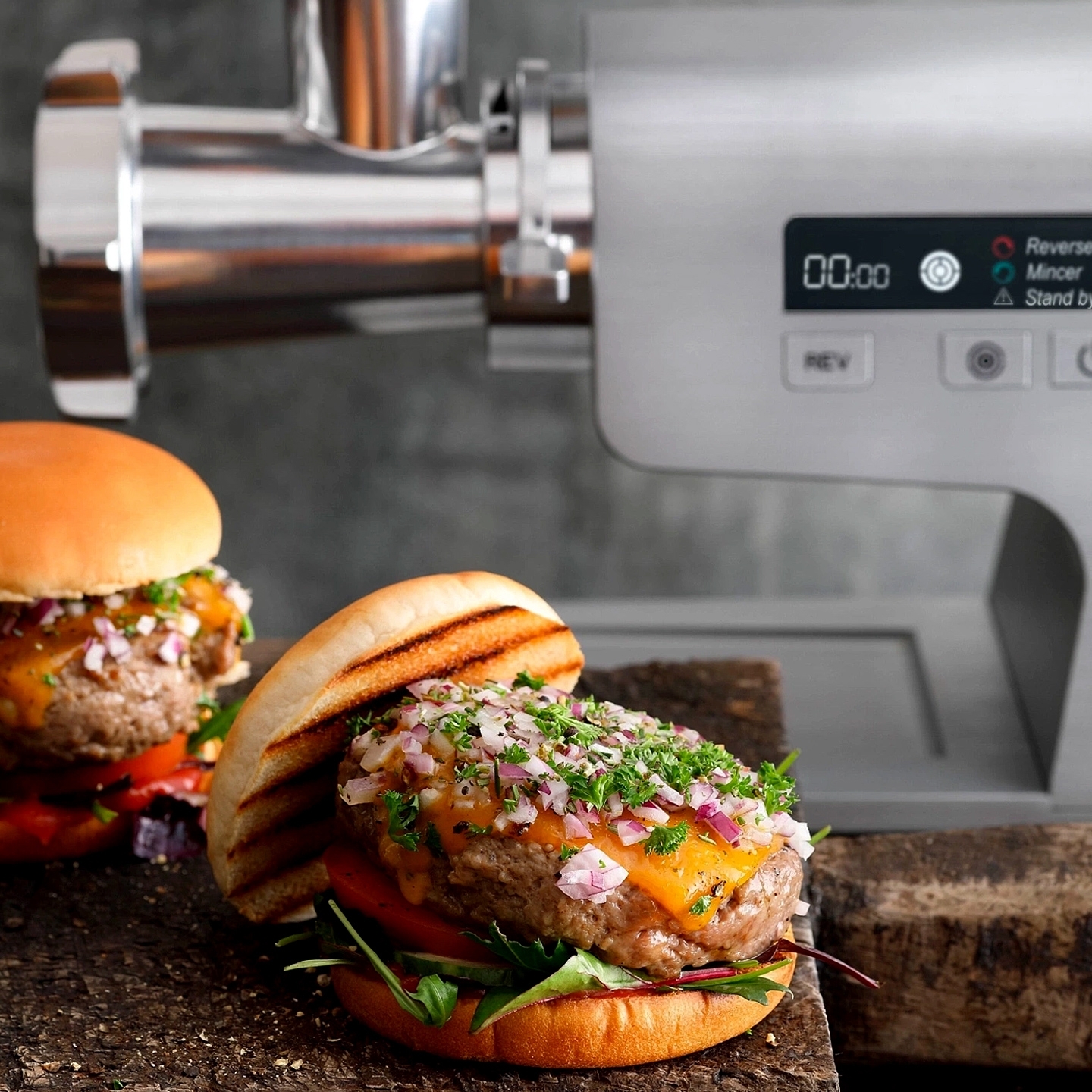 Burgers in front of a powerful electric meat grinder