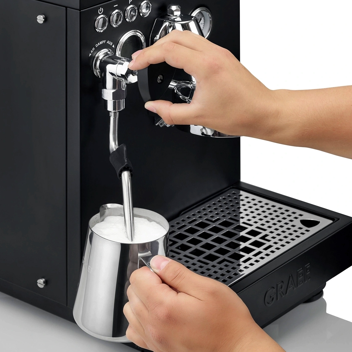 Hand frothing milk with espresso machine steam wand