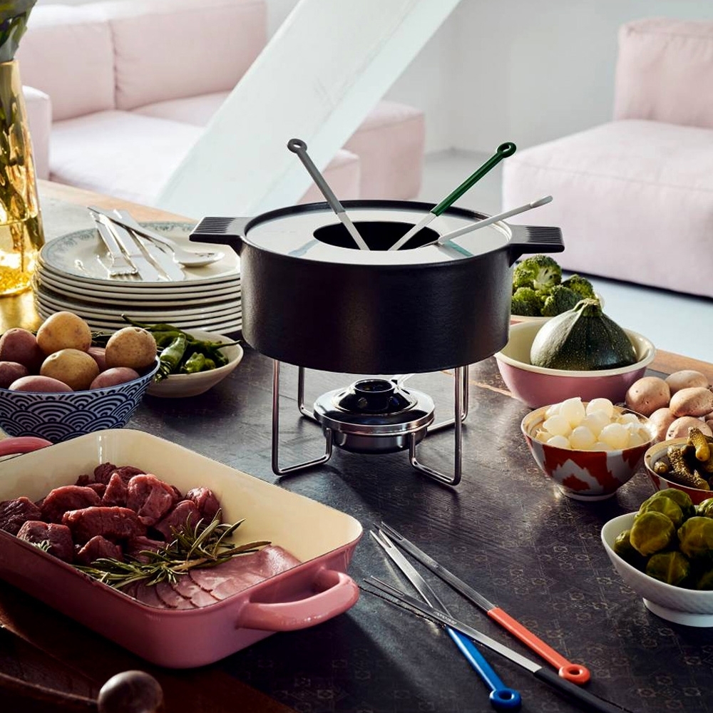 Fondue-Set mit Fleisch, Gemüse und Beilagen auf Tisch