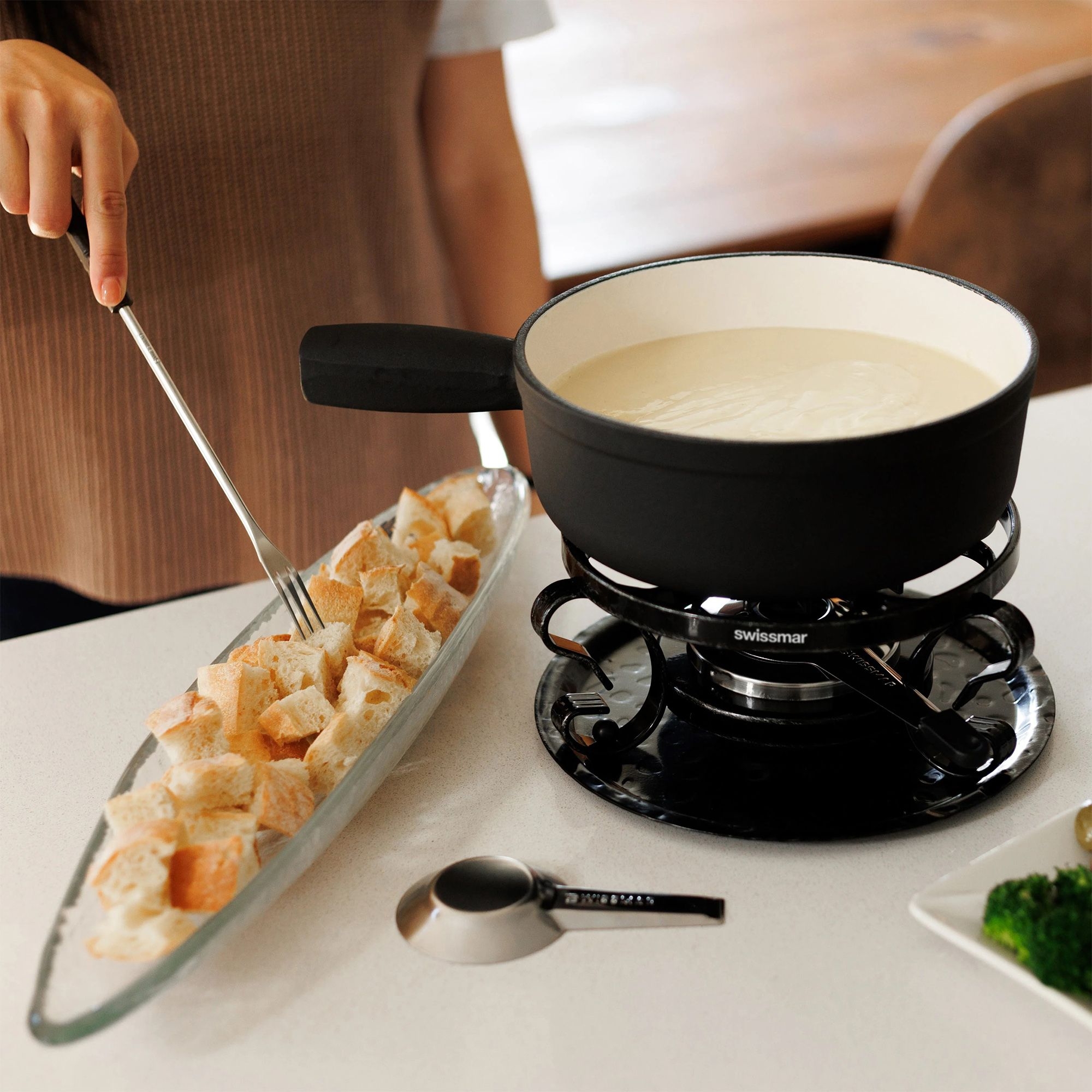 Fondue pot with cheese fondue and bread cubes