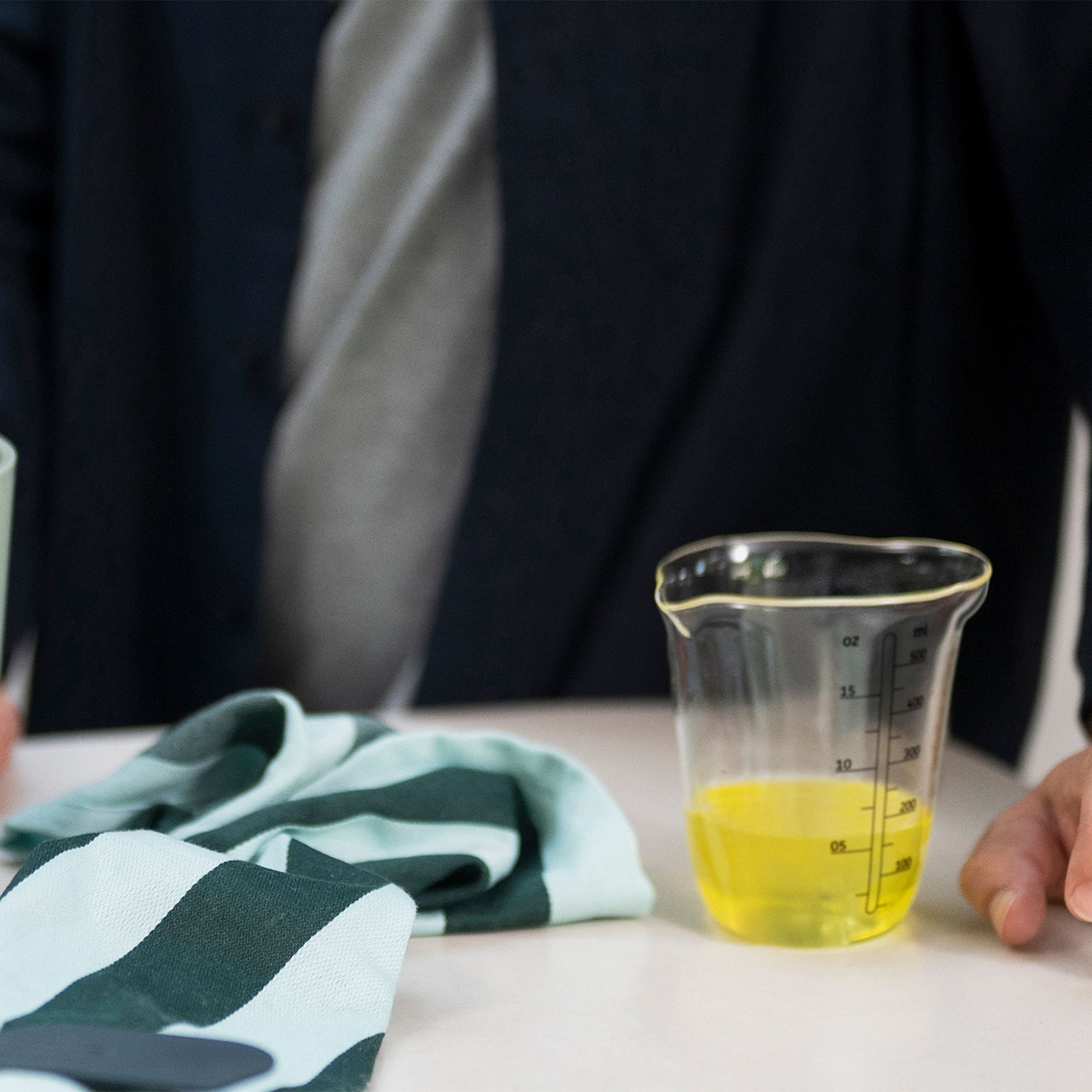 Transparent measuring cup with yellow liquid