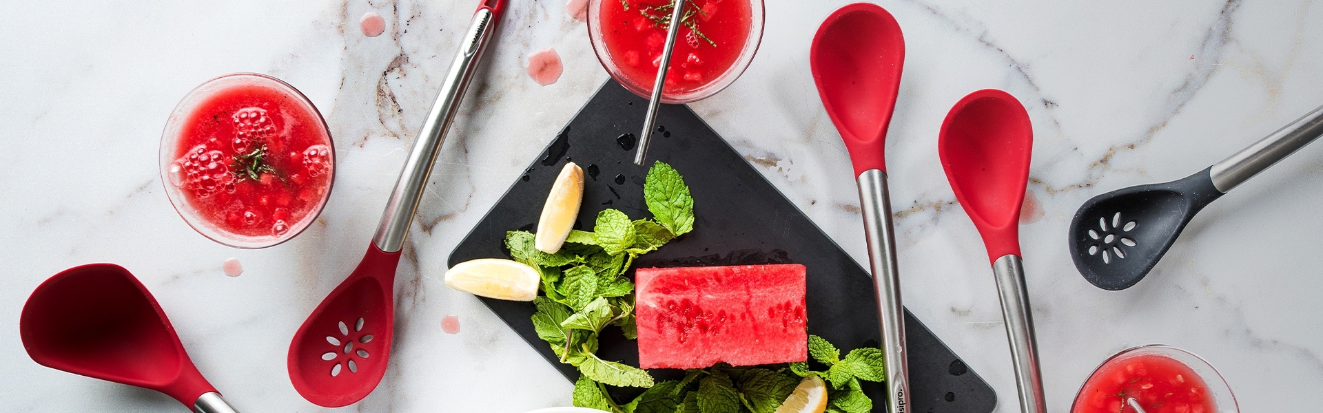 Red silicone cooking spoons with melon, mint and drinks