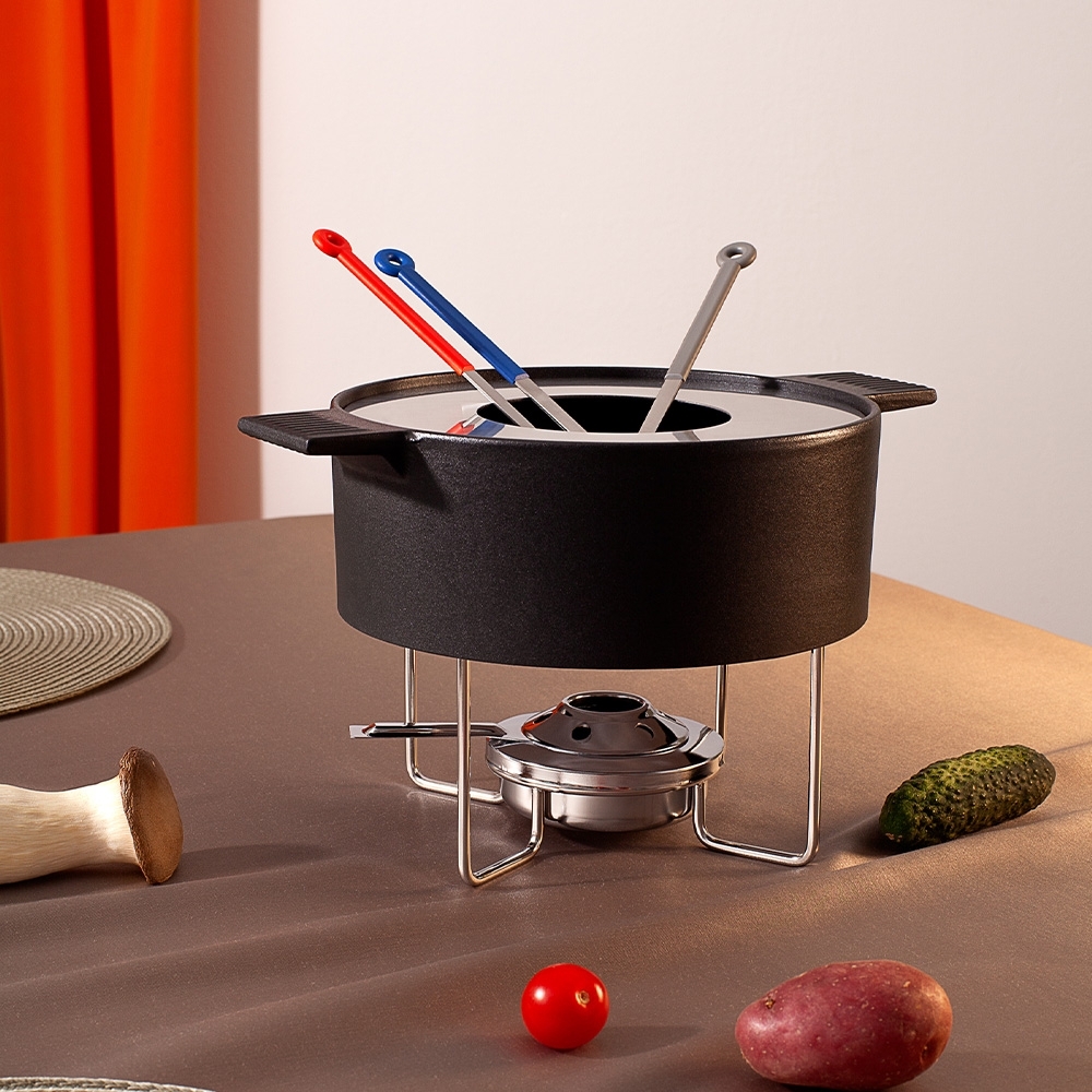 Schwarzes Fondue-Set mit Gabeln auf Tisch
